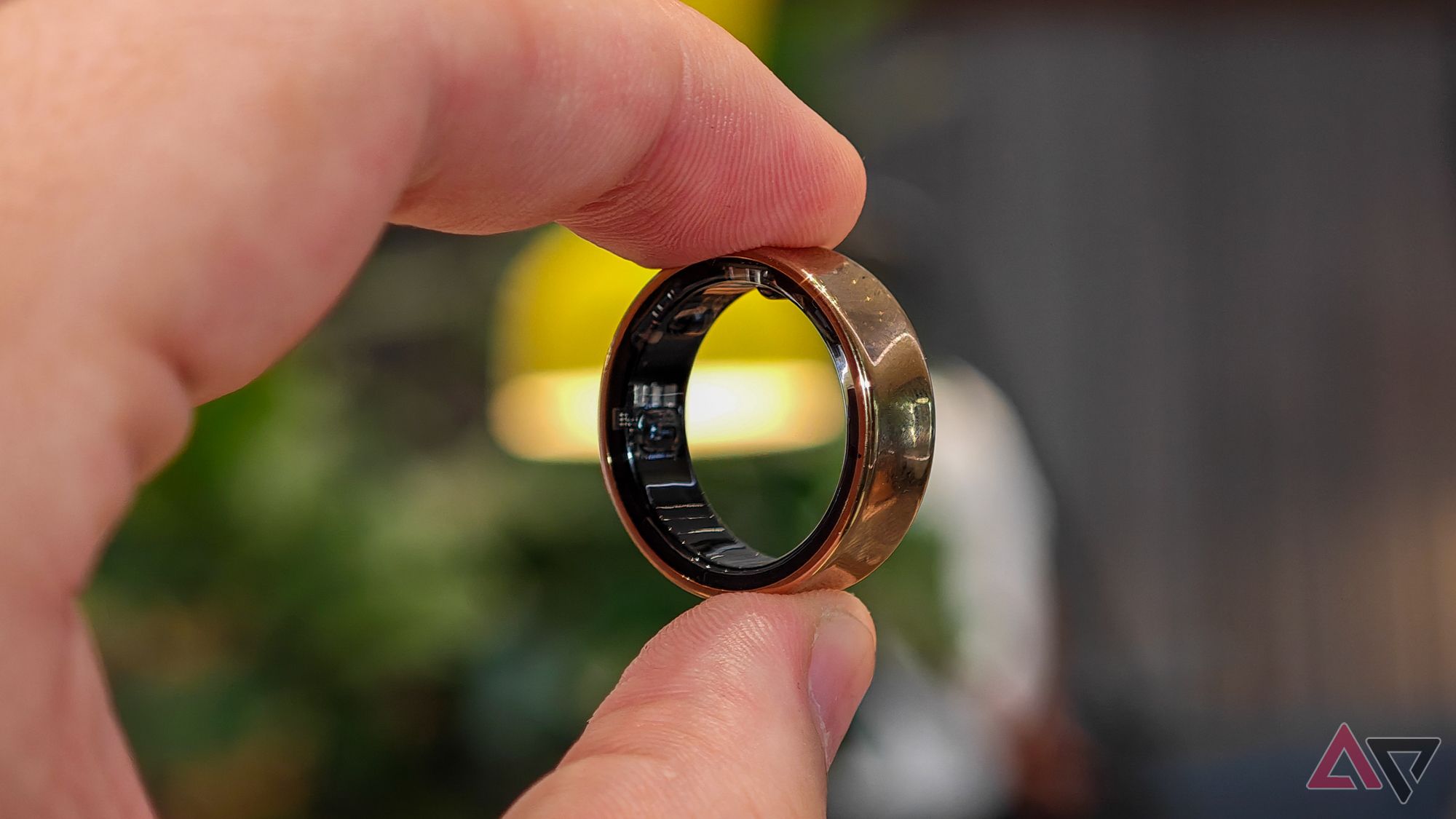 Samsung Galaxy Ring held in hand showing the ring's sensors