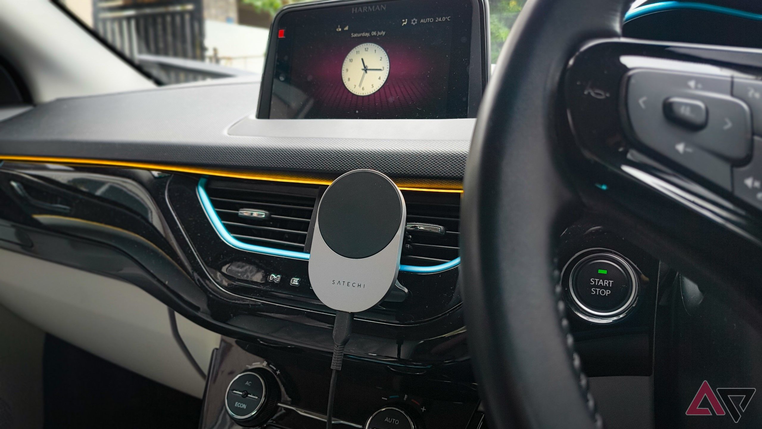 Wide shot of car dashboard with Satechi's wireless phone charger mounted to horizontal AC vents 