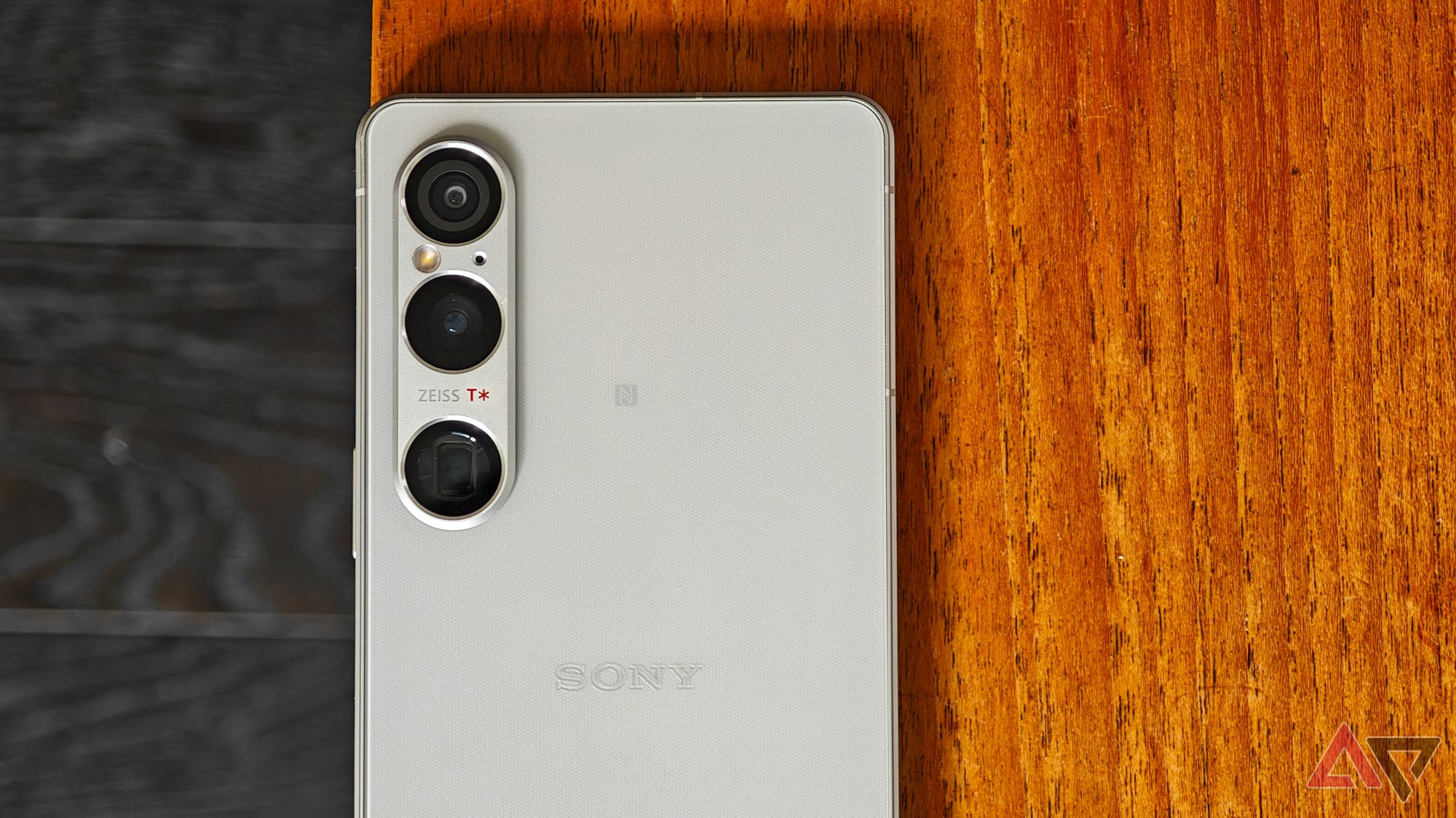 A photo of the Sony Xperia 1 VI resting on a wooden table, focusing on the cameras