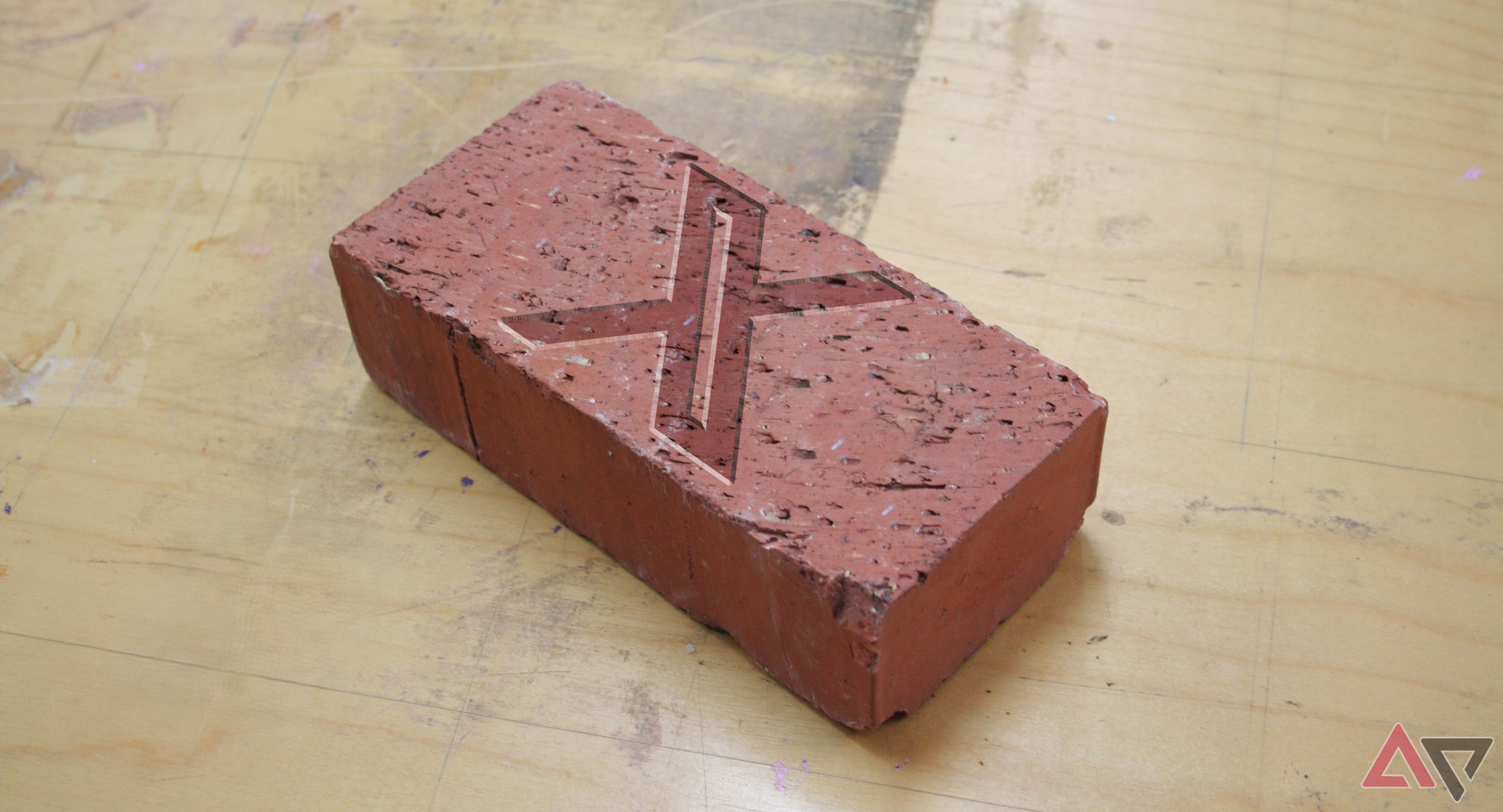 Twitter logo on brick laying on dirty wood floor