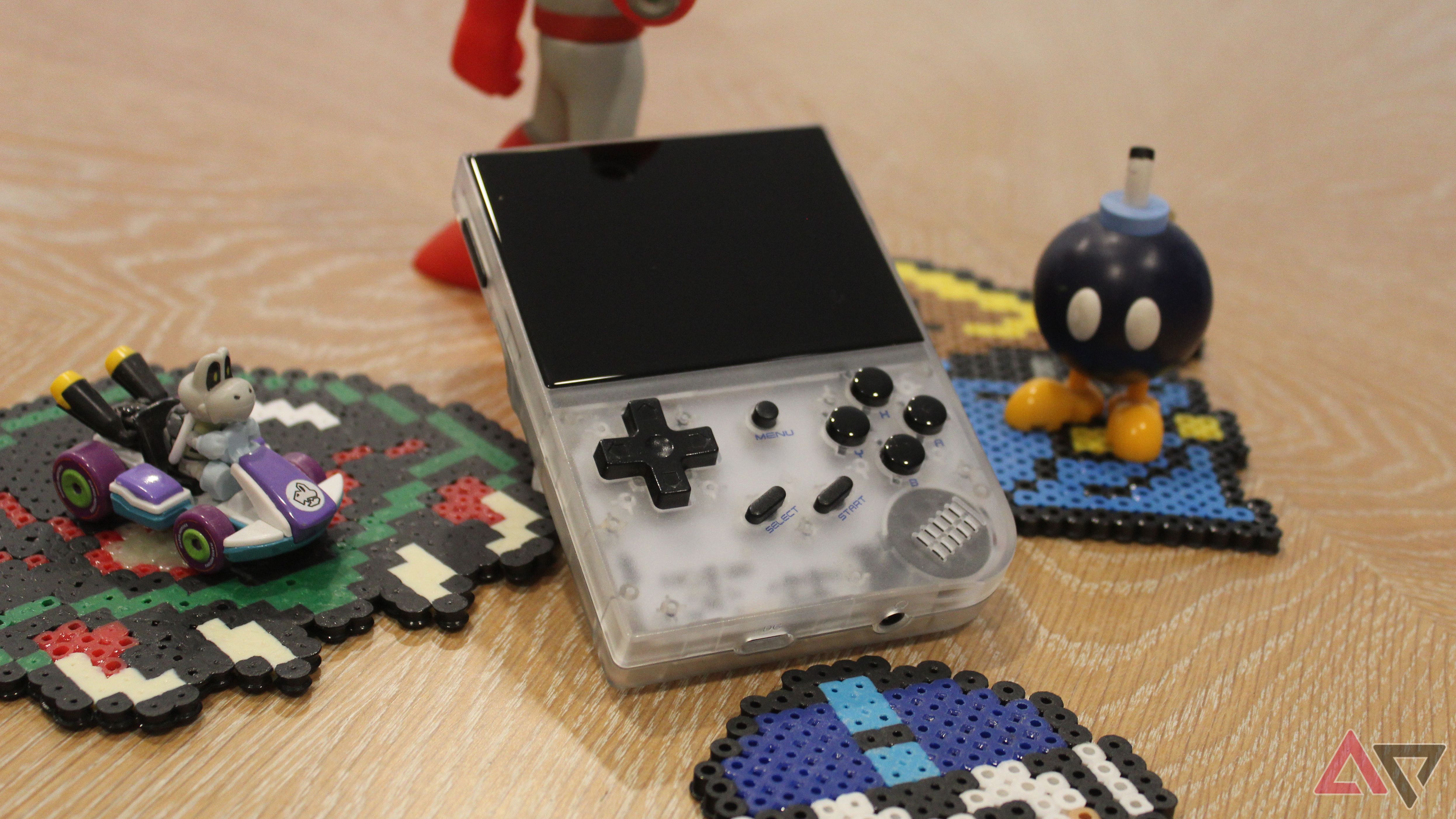 Anbernic RG35XX (2024) on table with gaming memorabilia