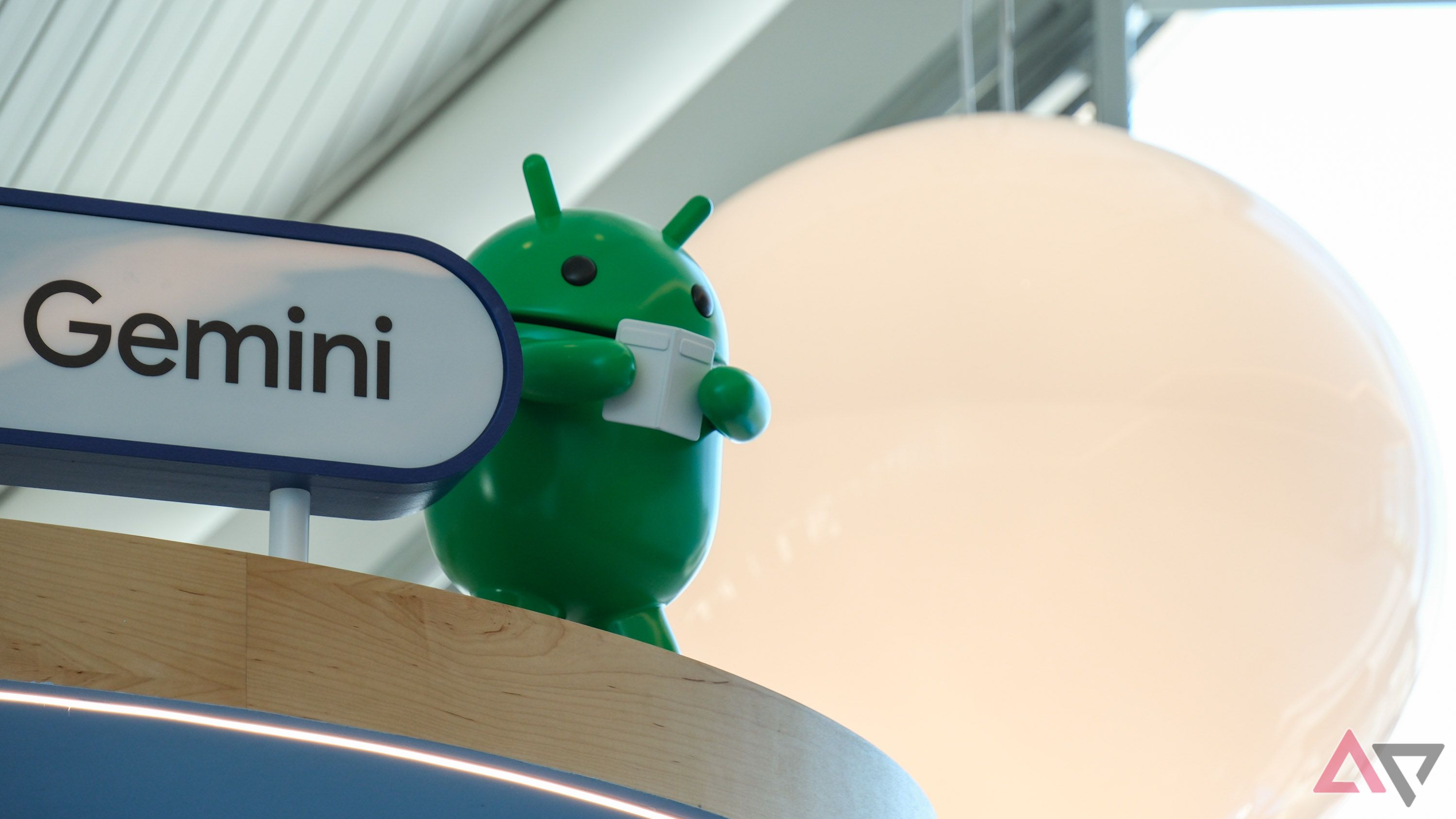 Android bot mascot next to a sign that says 