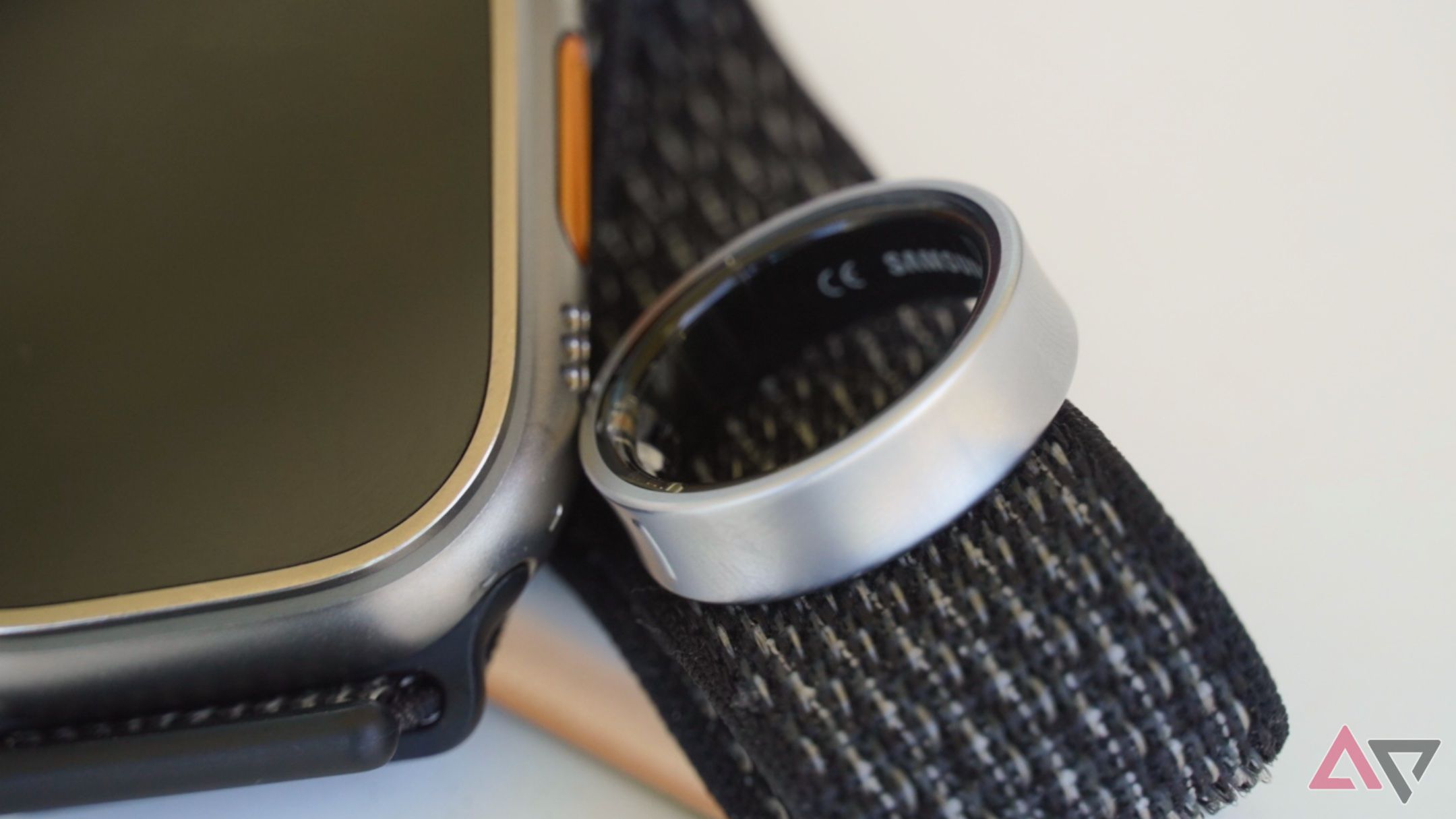 The Galaxy Ring laying on an Apple Watch Ultra strap.