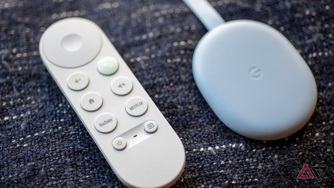 An image of the Chromecast 2022 and its remote control against a textured background.