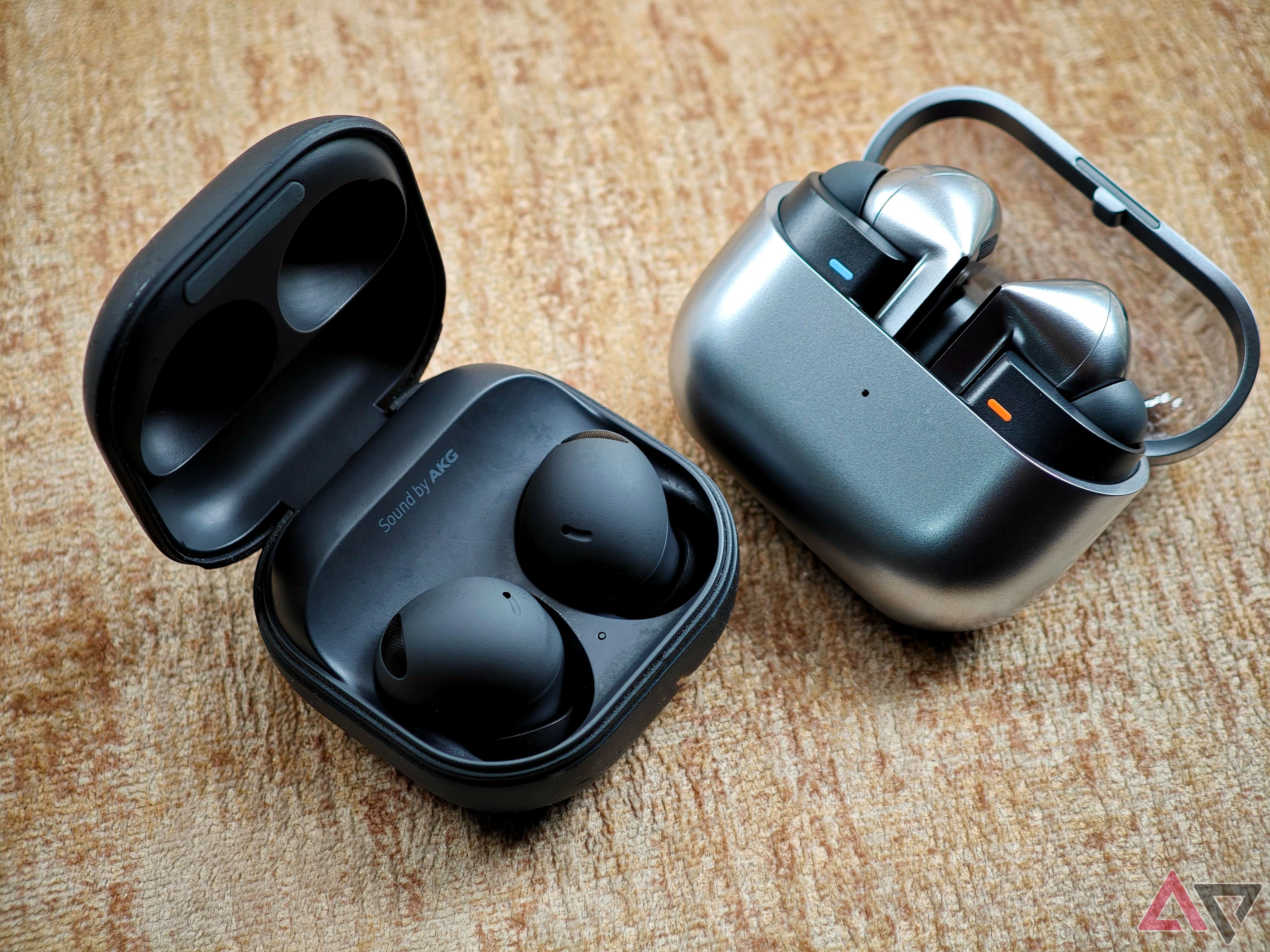 Samsung Galaxy Buds 2 Pro and Buds 3 Pro in their cases on a textured surface