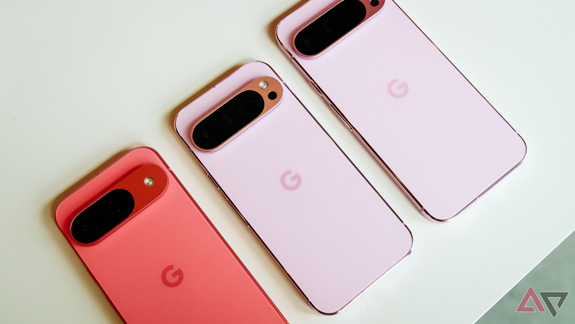 Three pink Google Pixel 9 models face down.