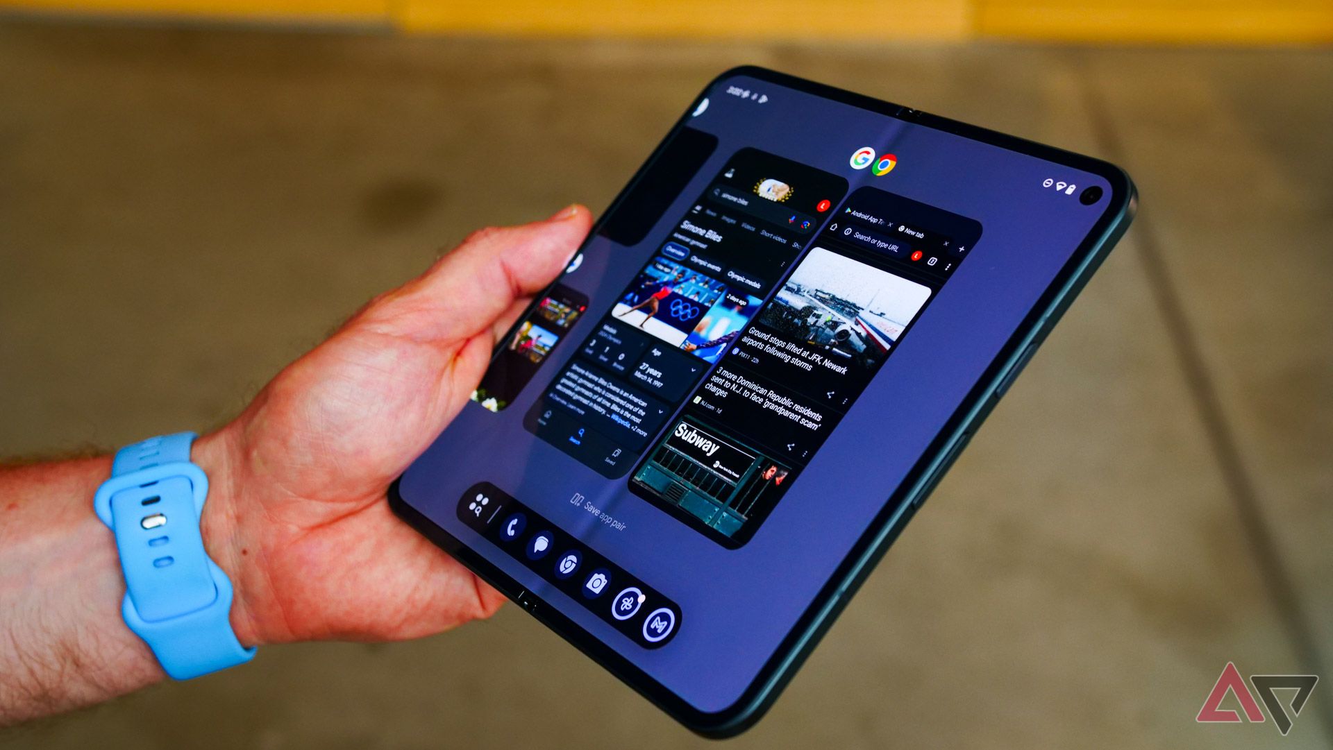 The Google Pixel 9 Pro Fold held in a hand unfolded with an app pair open for multitasking