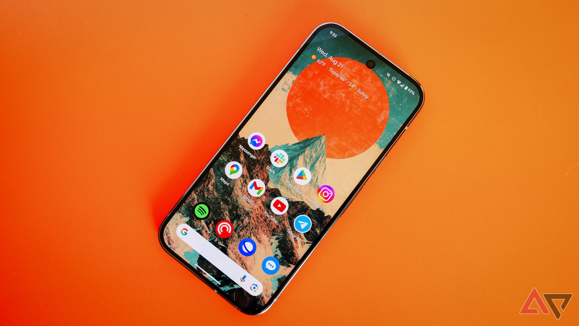 The Pixel 9 Pro on an orange backdrop with the homescreen showing