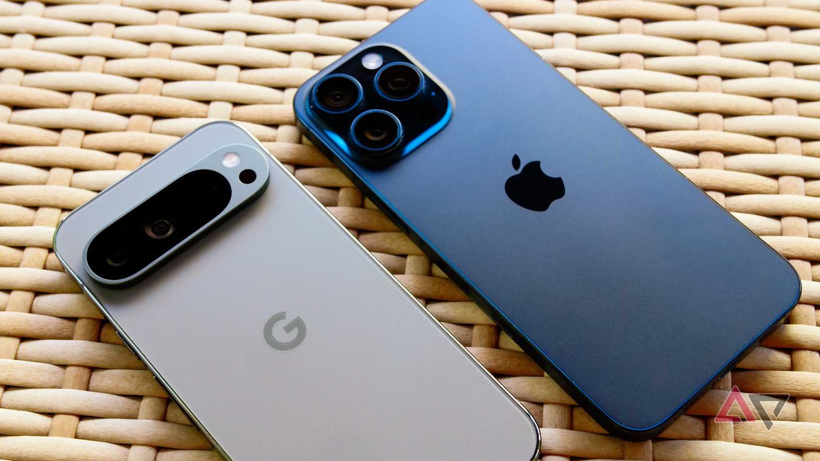 A Pixel 9 Pro next to an iPhone 15 Pro Max on a wicker table