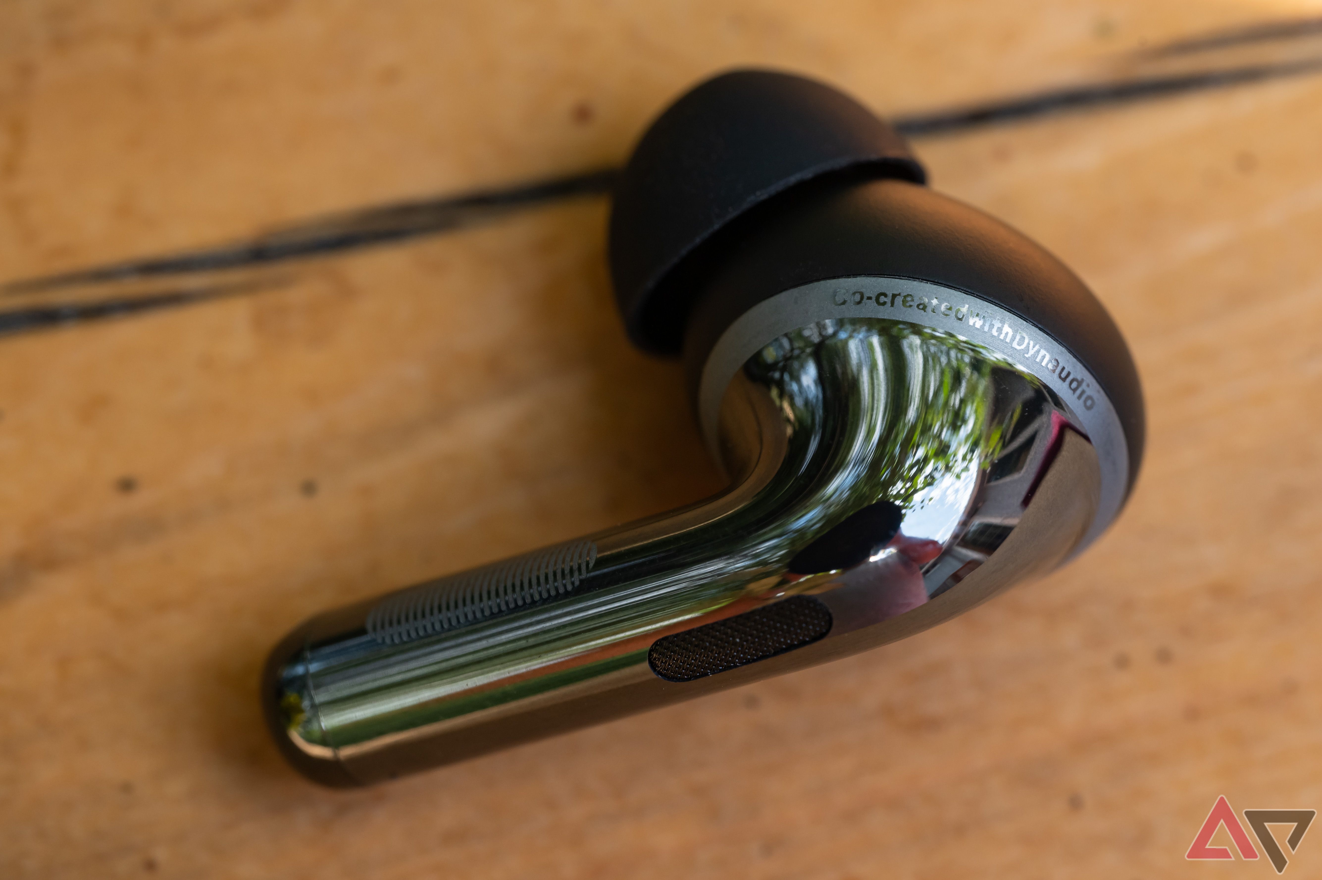 OnePlus Buds Pro 3 Earbud angled view on wooden surface