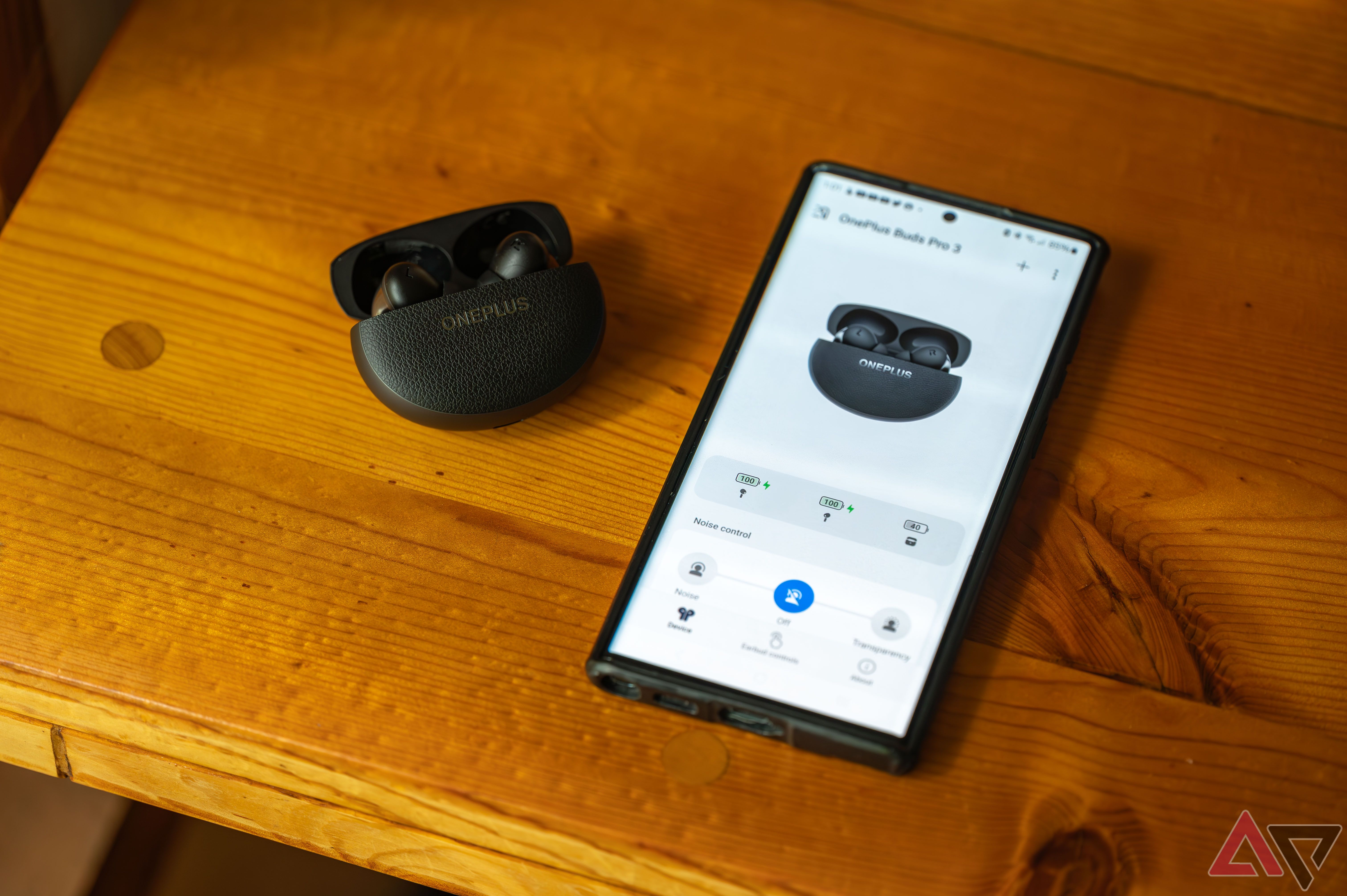 OnePlus Buds Pro 3 next to android phone with companion app onscreen.