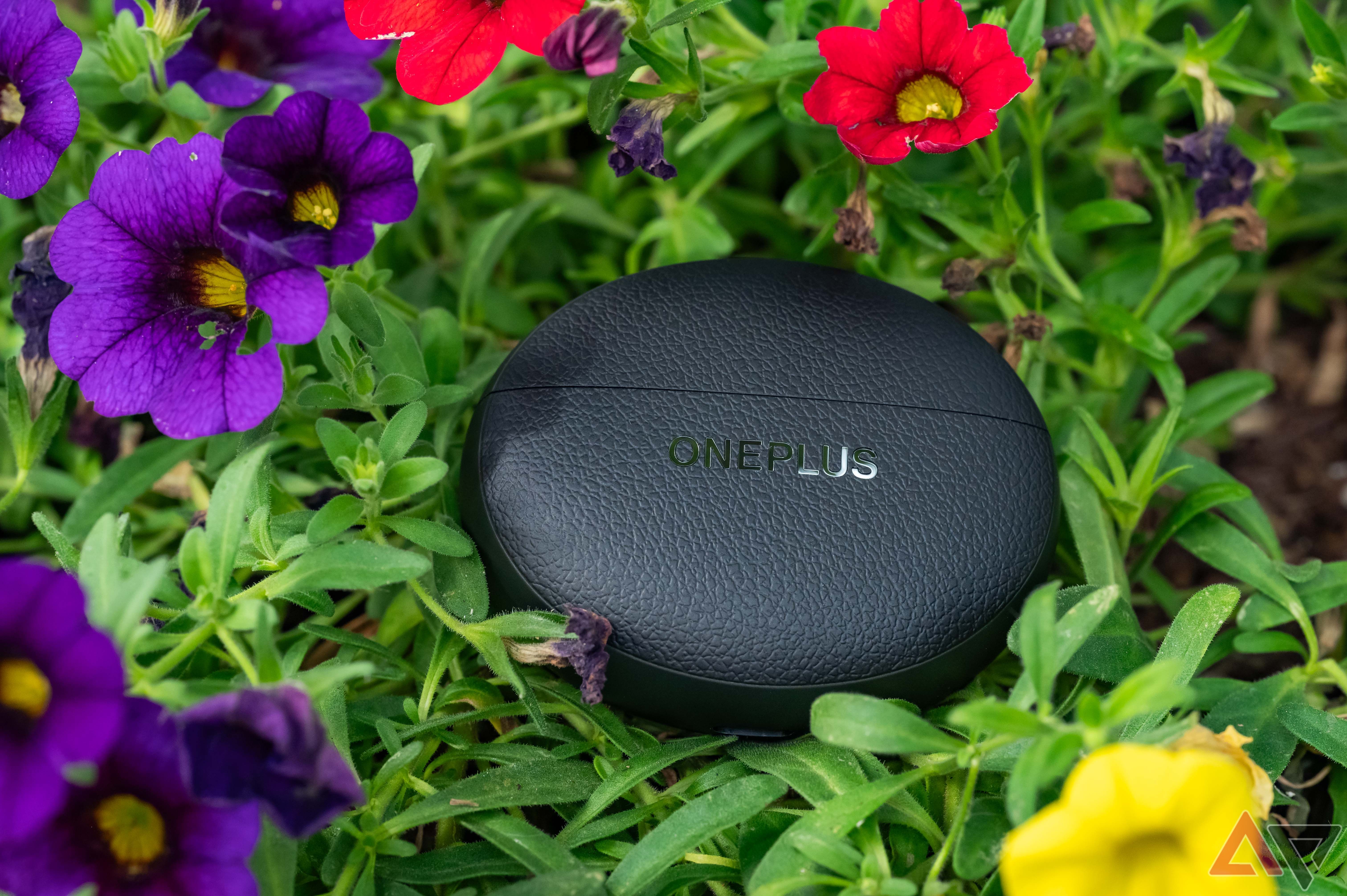 OnePlus Buds Pro 3 case among flowers, front view