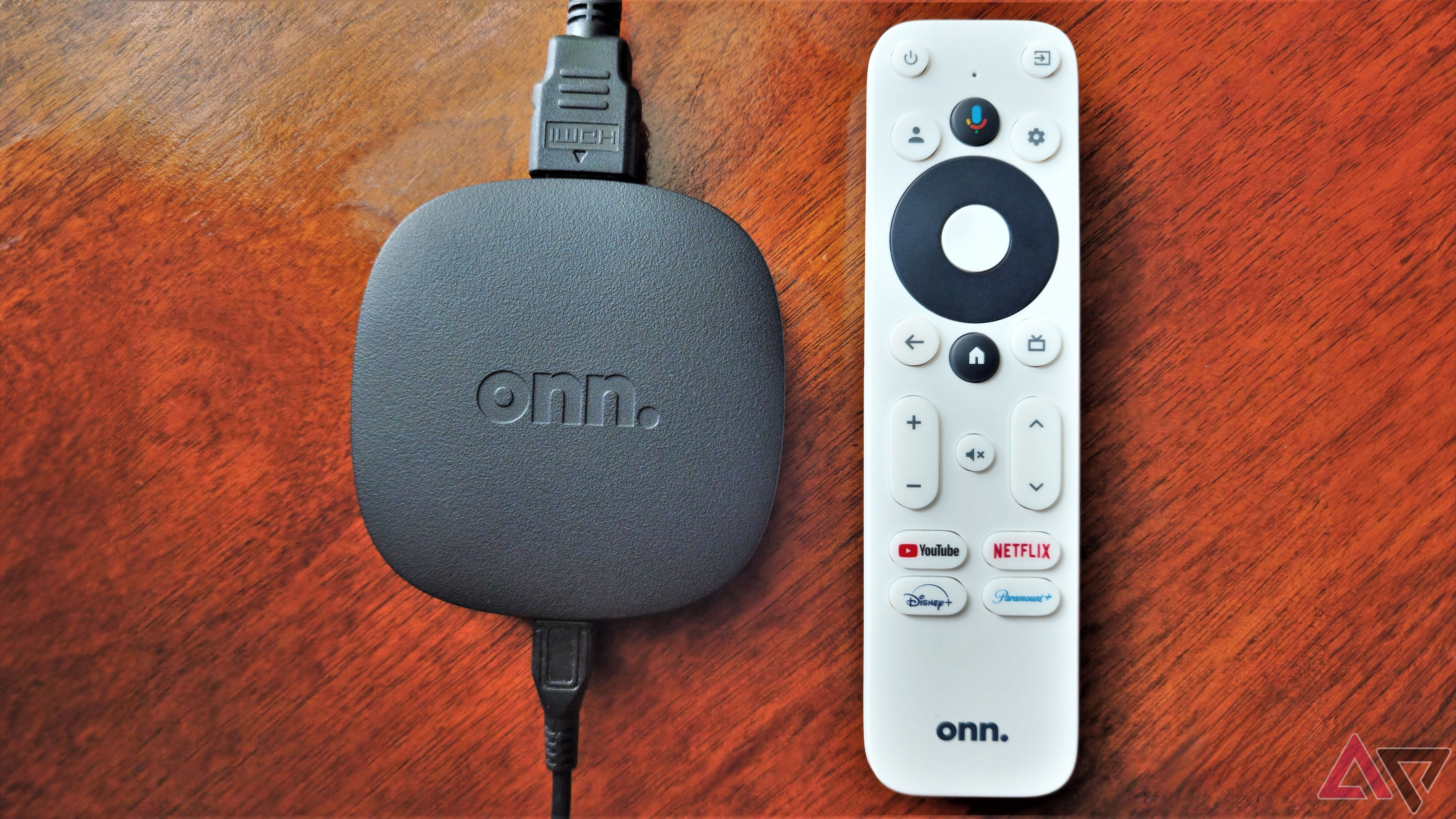 The Onn streaming box on a wooden table next to its remote.