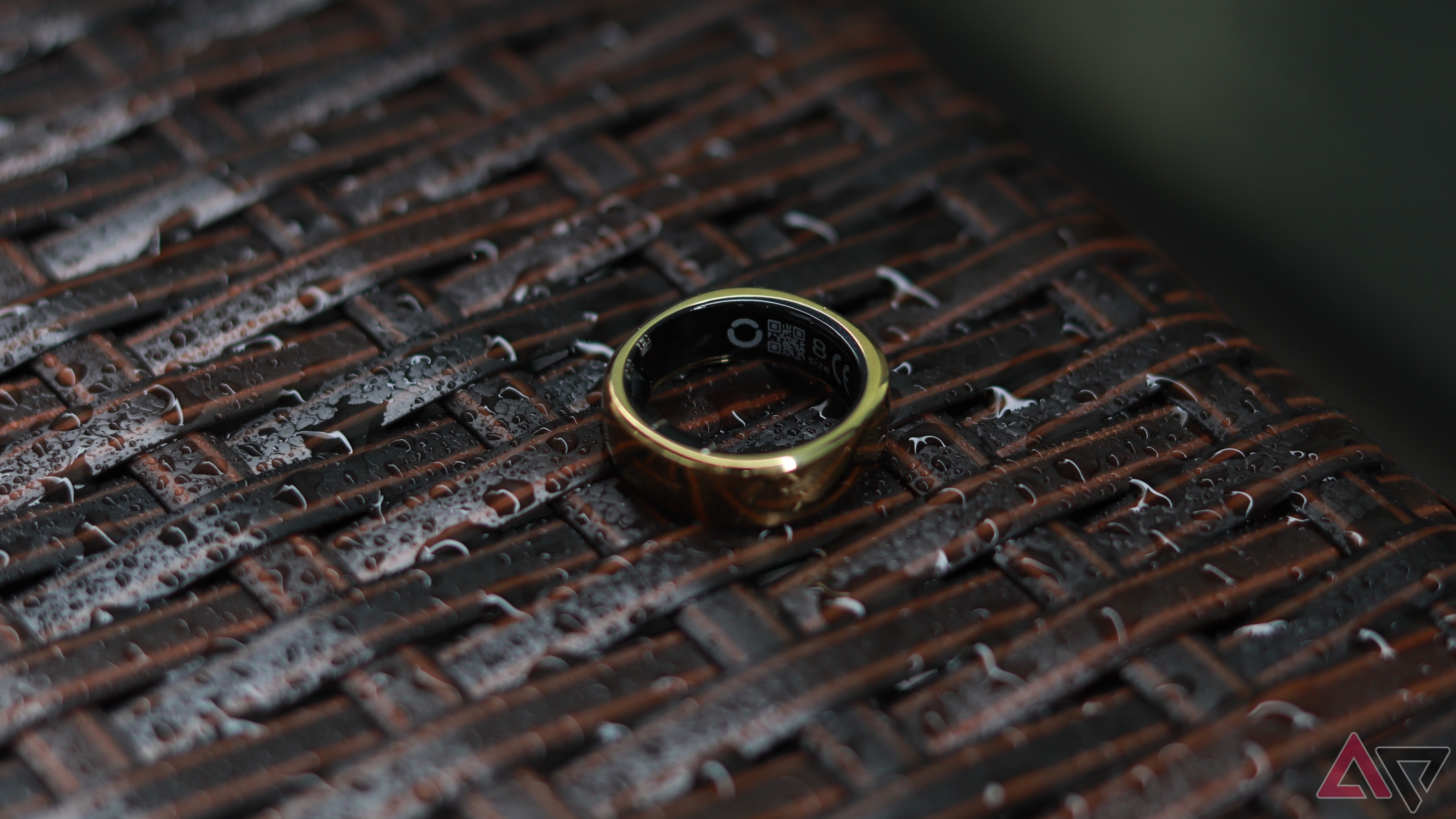 RingConn Gen 2 smart ring on a woven surface with water droplets