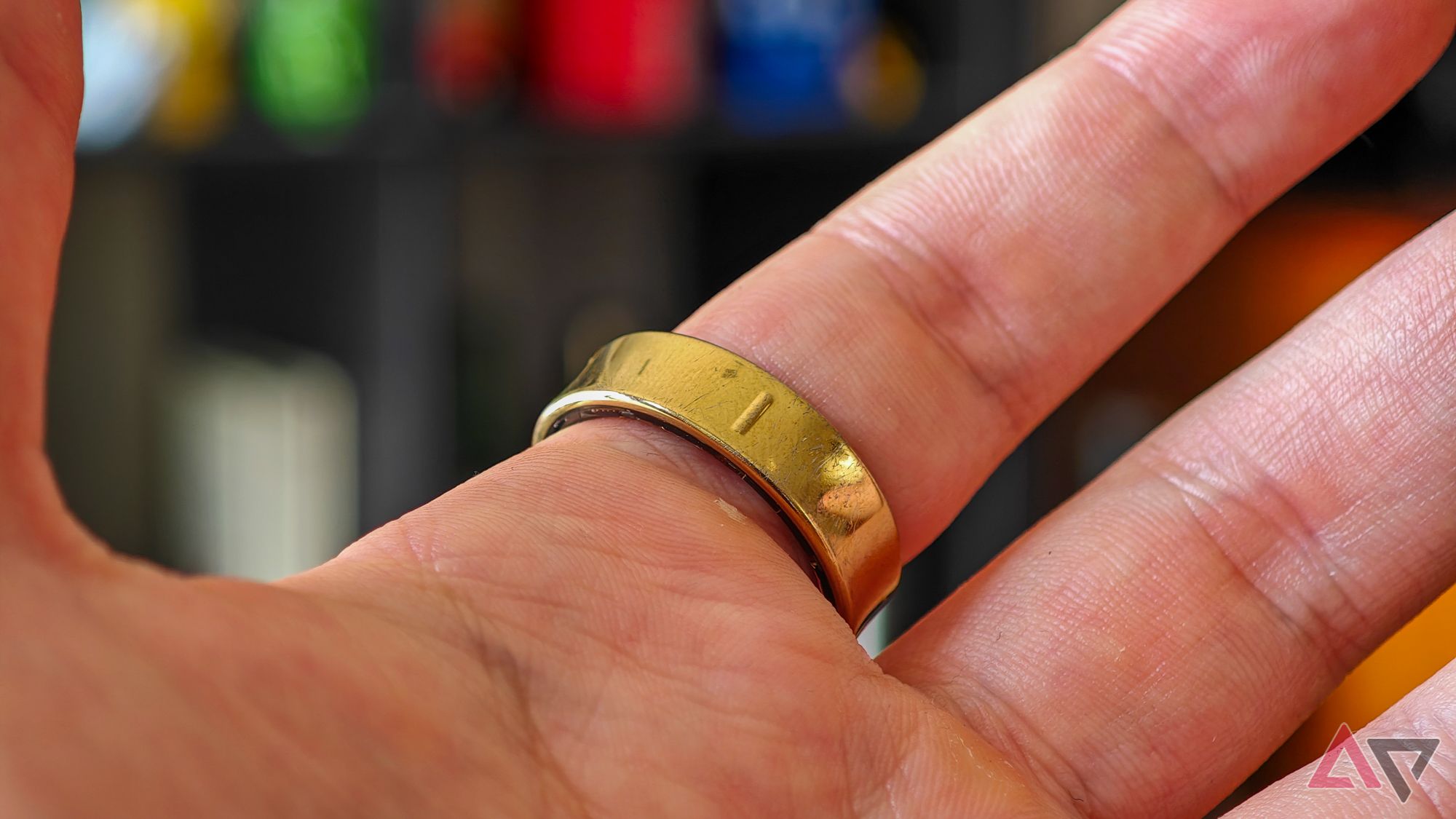 A gold Samsung Galaxy ring on a person's index finger, shot from the bottom to show the ridge that marks the bottom