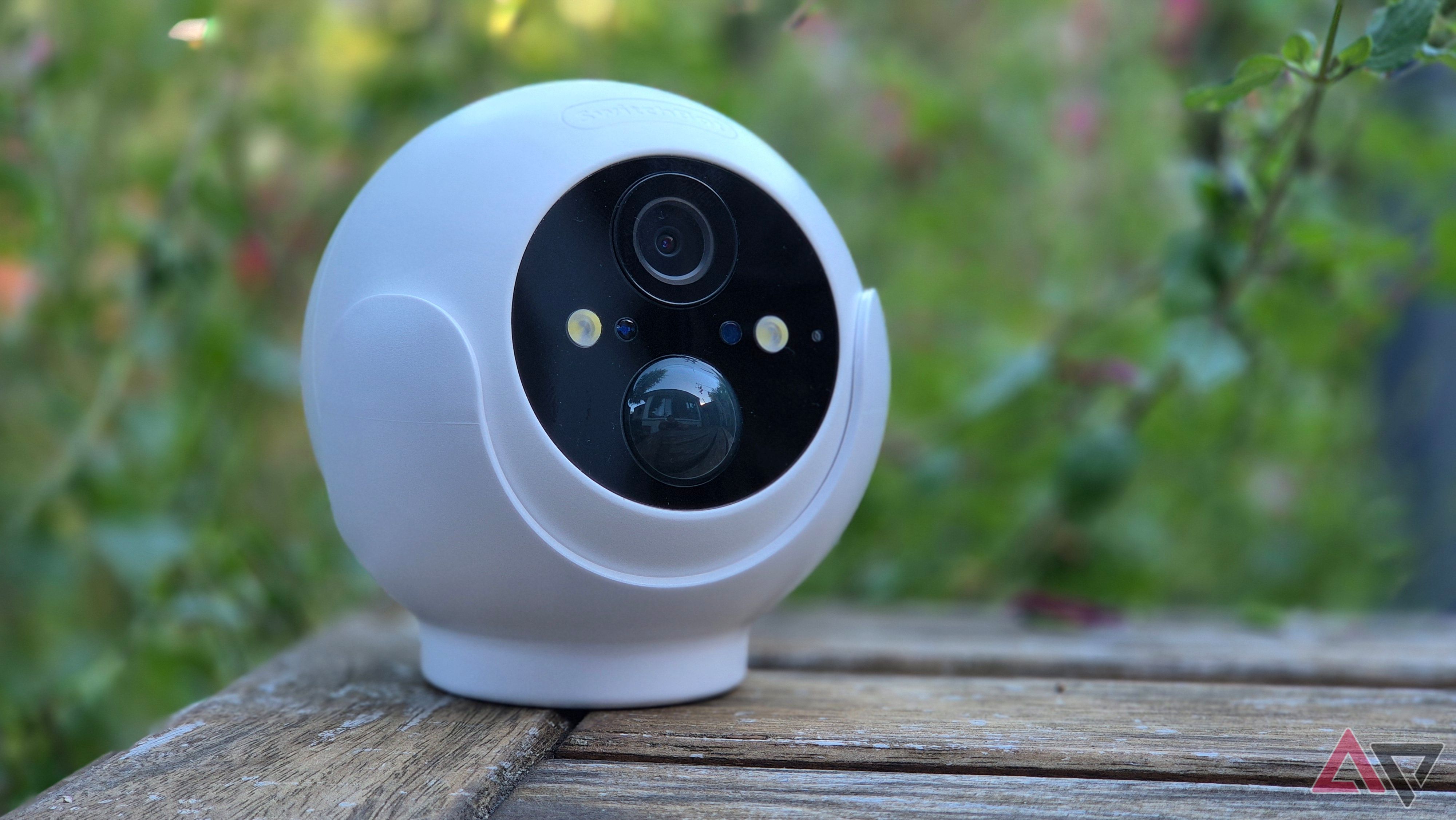 Switchbot Outdoor Security Cam 2K on a table with plants in the background