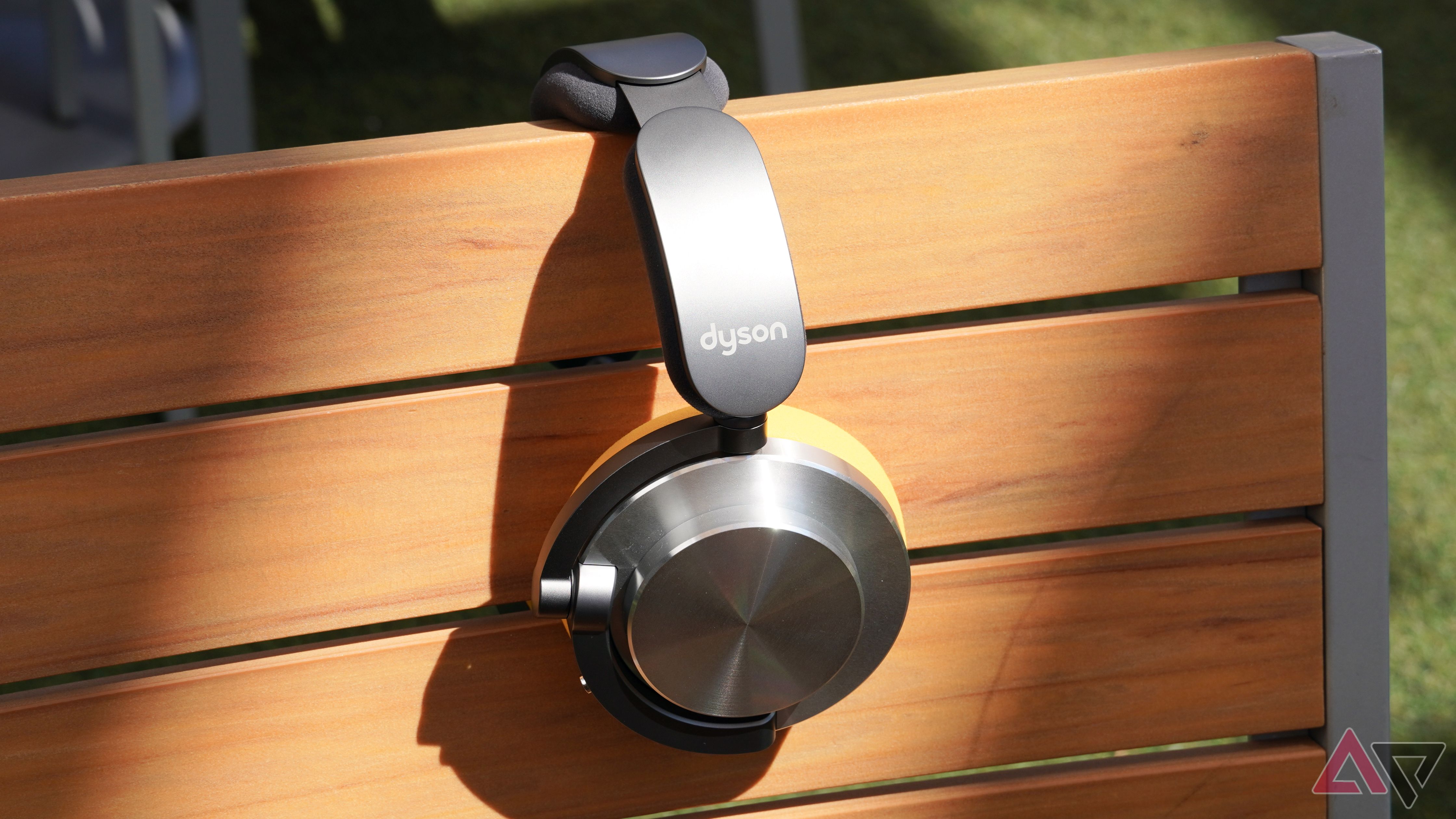 The Dyson OnTrac headphones hanging off a chair under a ray of sunlight.