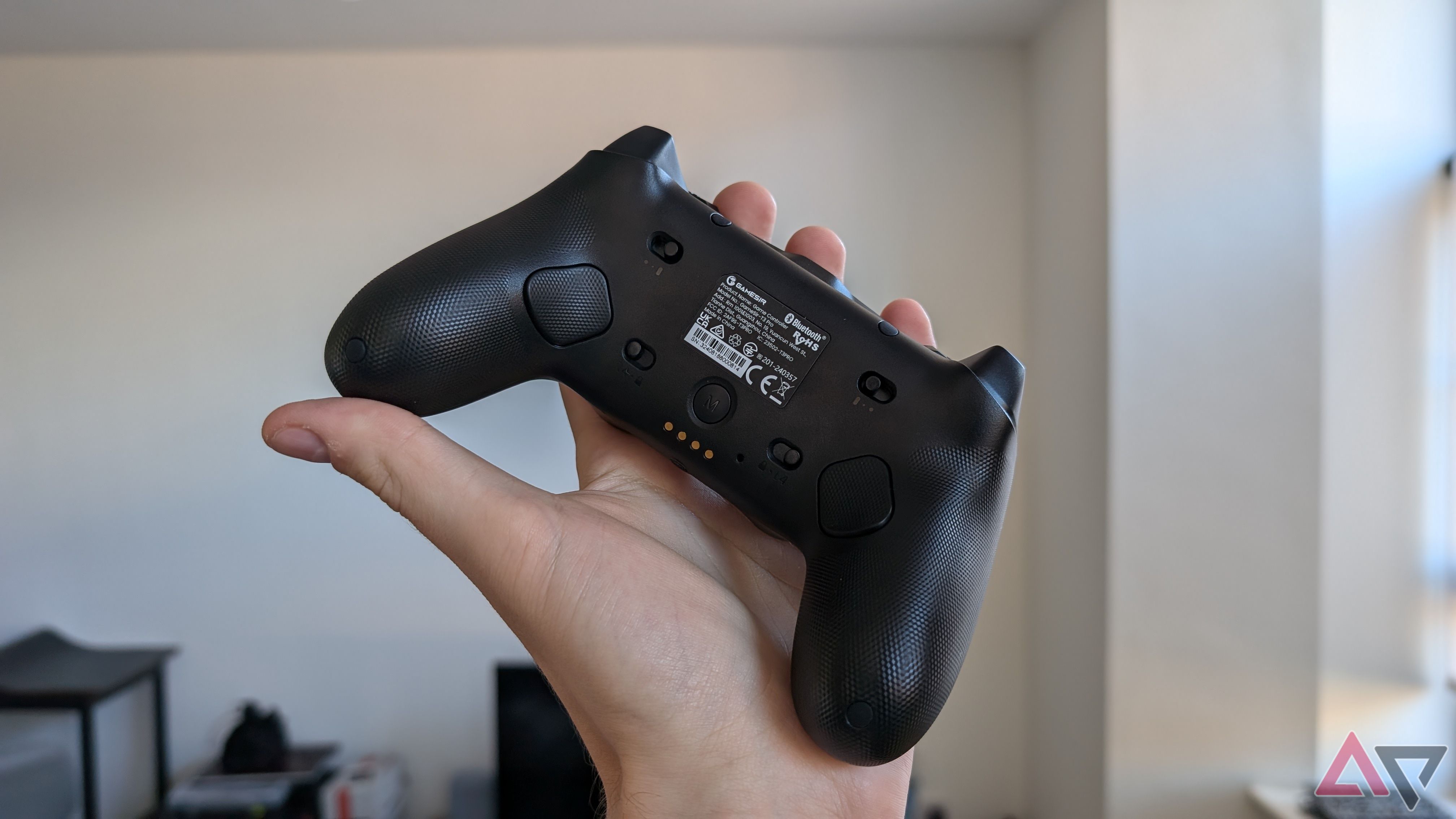 hand holding black gamesir controller showing back