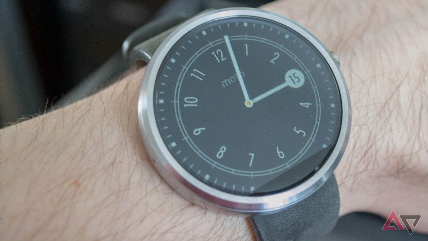 Moto 360 first gen worn on writst showing clock face