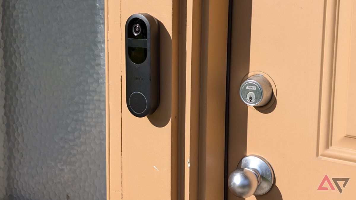 Reolink Battery Doorbell on wall next to exterior door during the day