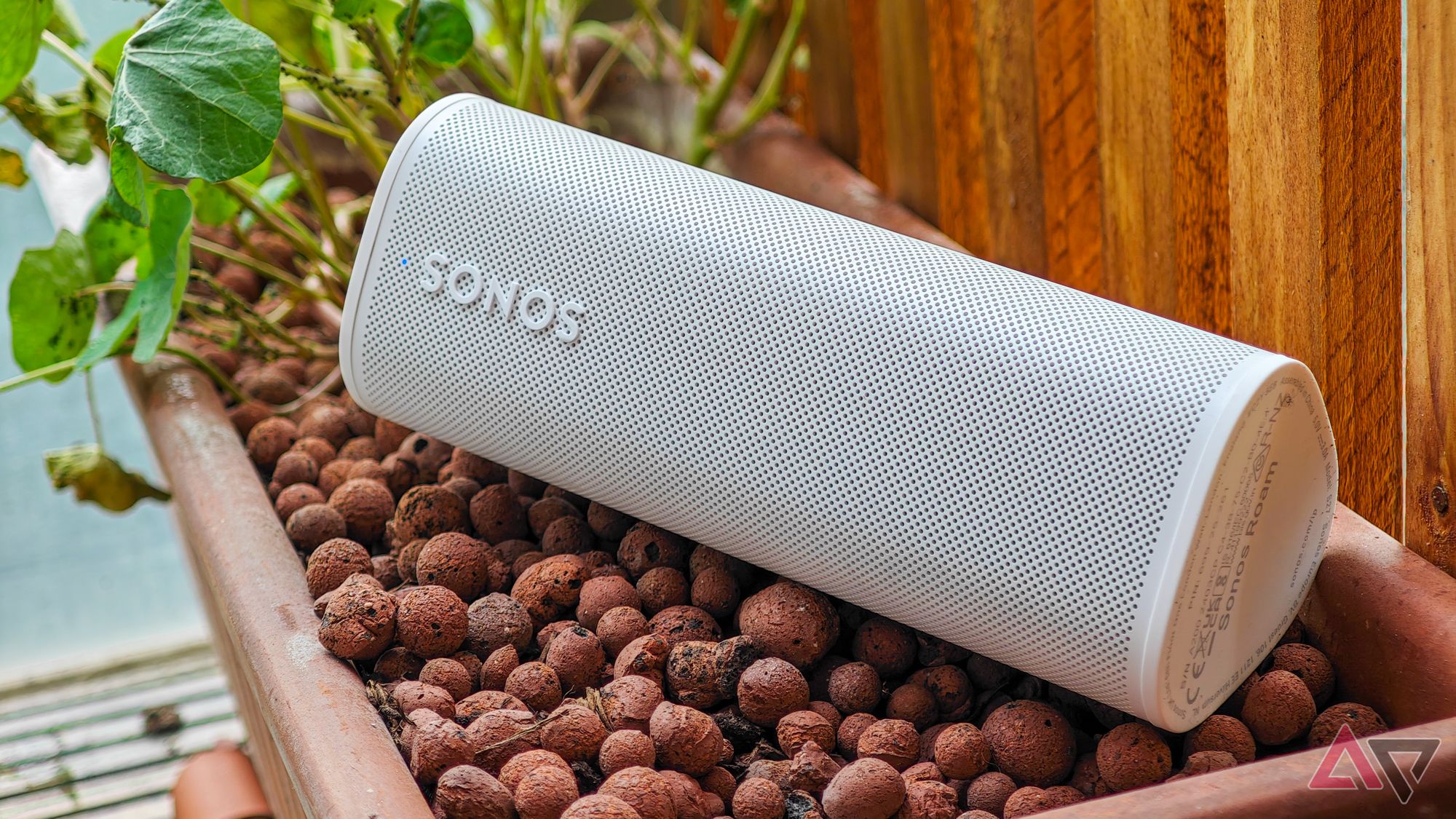 Sonos Roam 2 speaker in white lying on top of a plant pot