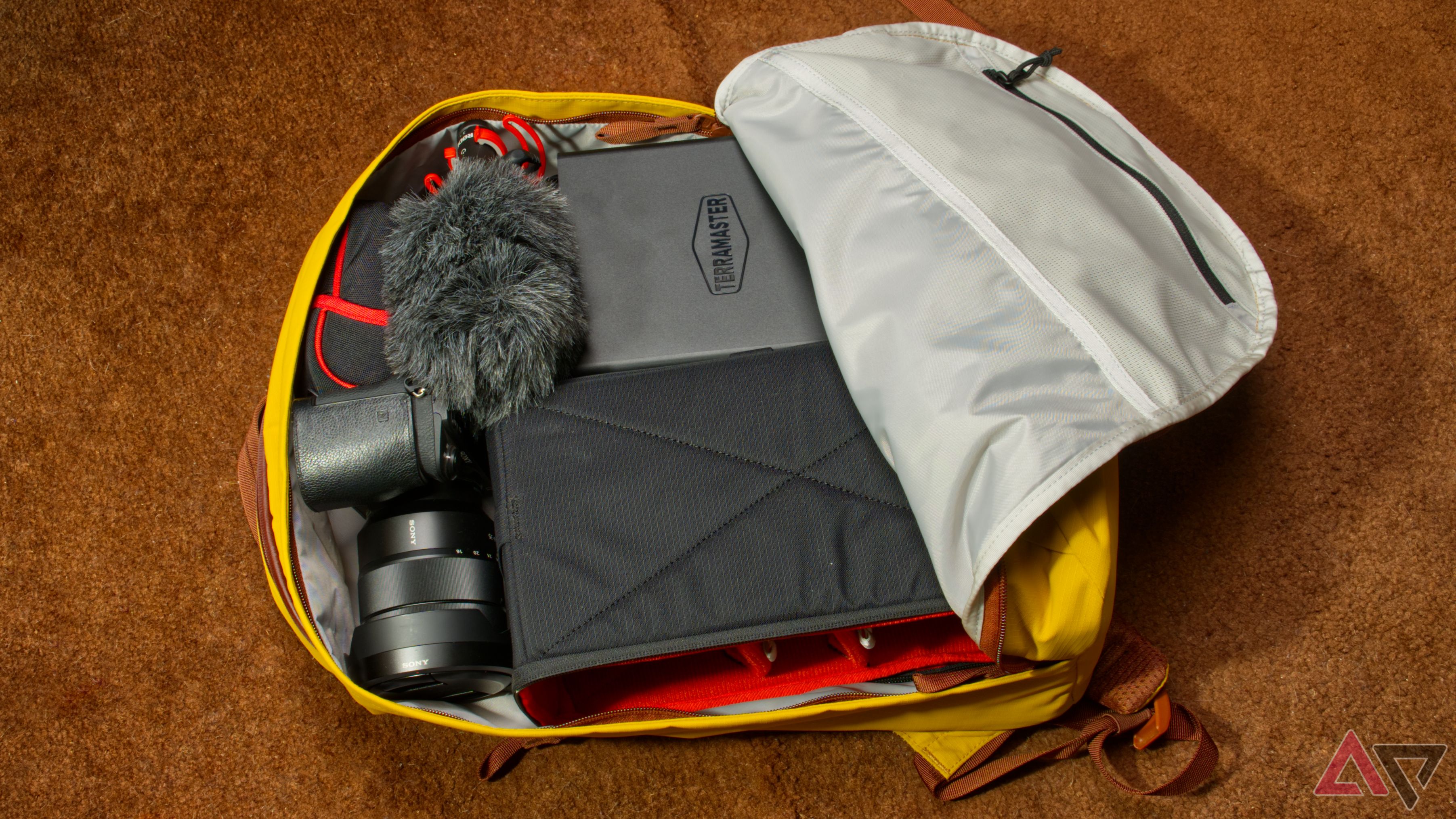 Yellow backpack filled with a TerraMaster F8 SSD Plus NAS, camera, and microphone