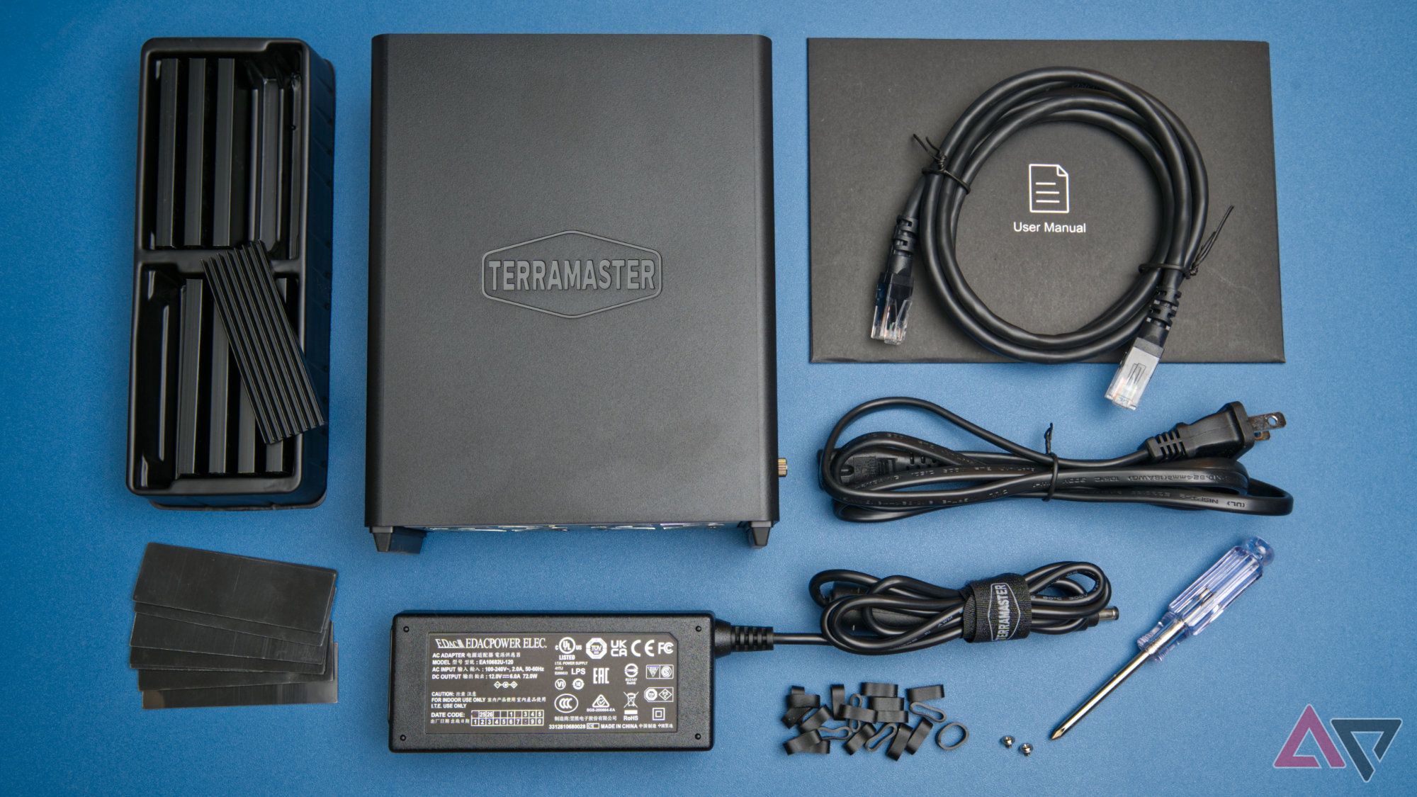 F8 SSD Plus NAS package contents laid out flat on a blue background