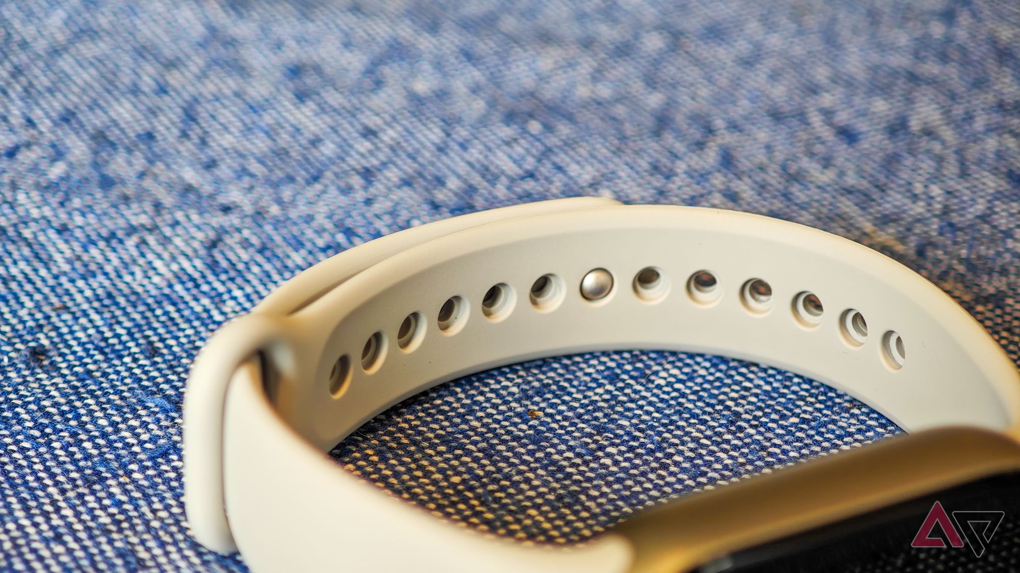 Xiaomi Smart Band 9 lying on a blue tablecloth showing how the TPU band attaches