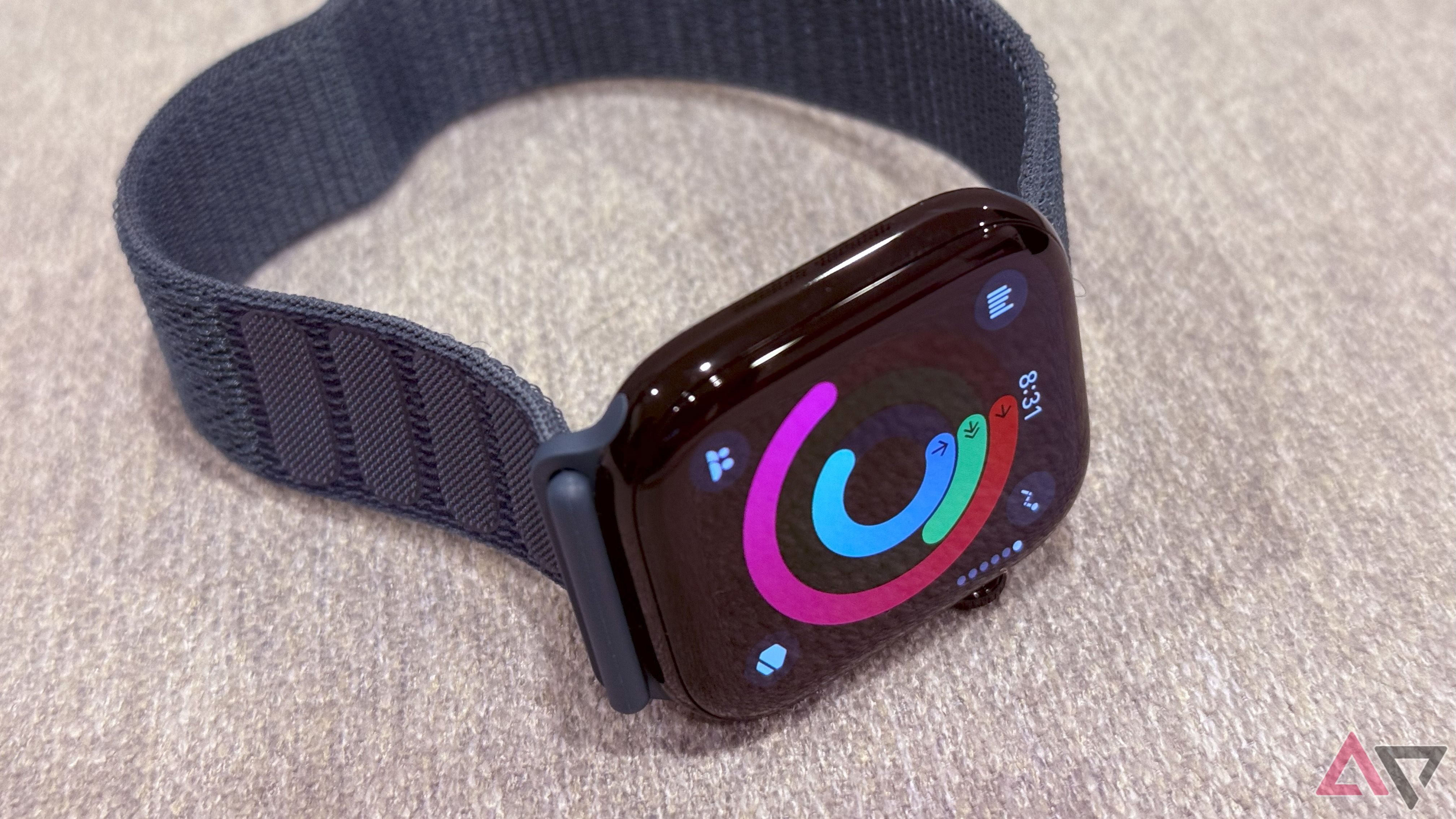 The Apple Watch Series 10, off a wrist with rings on the display