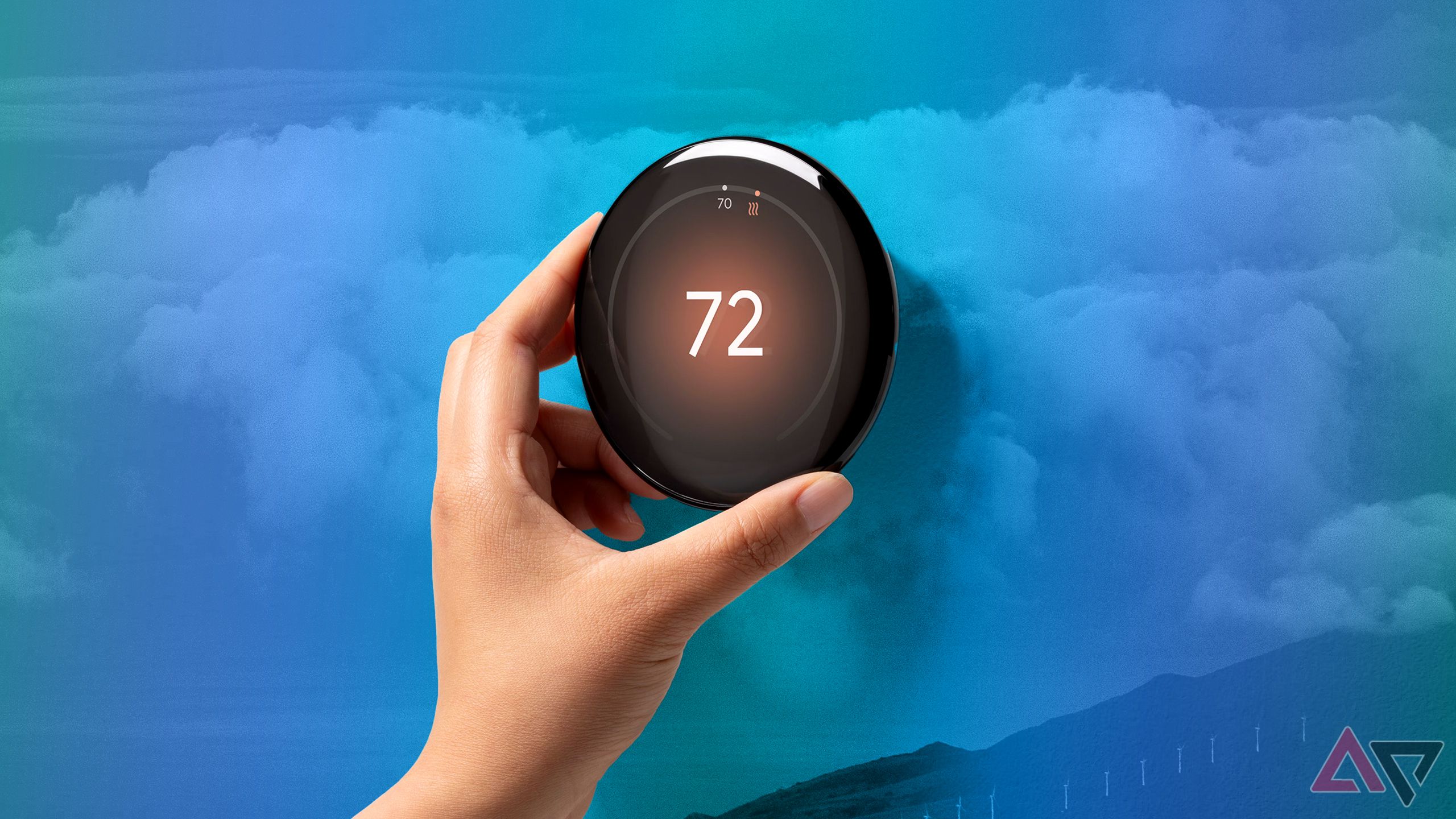 hand holding black thermostat on blue background