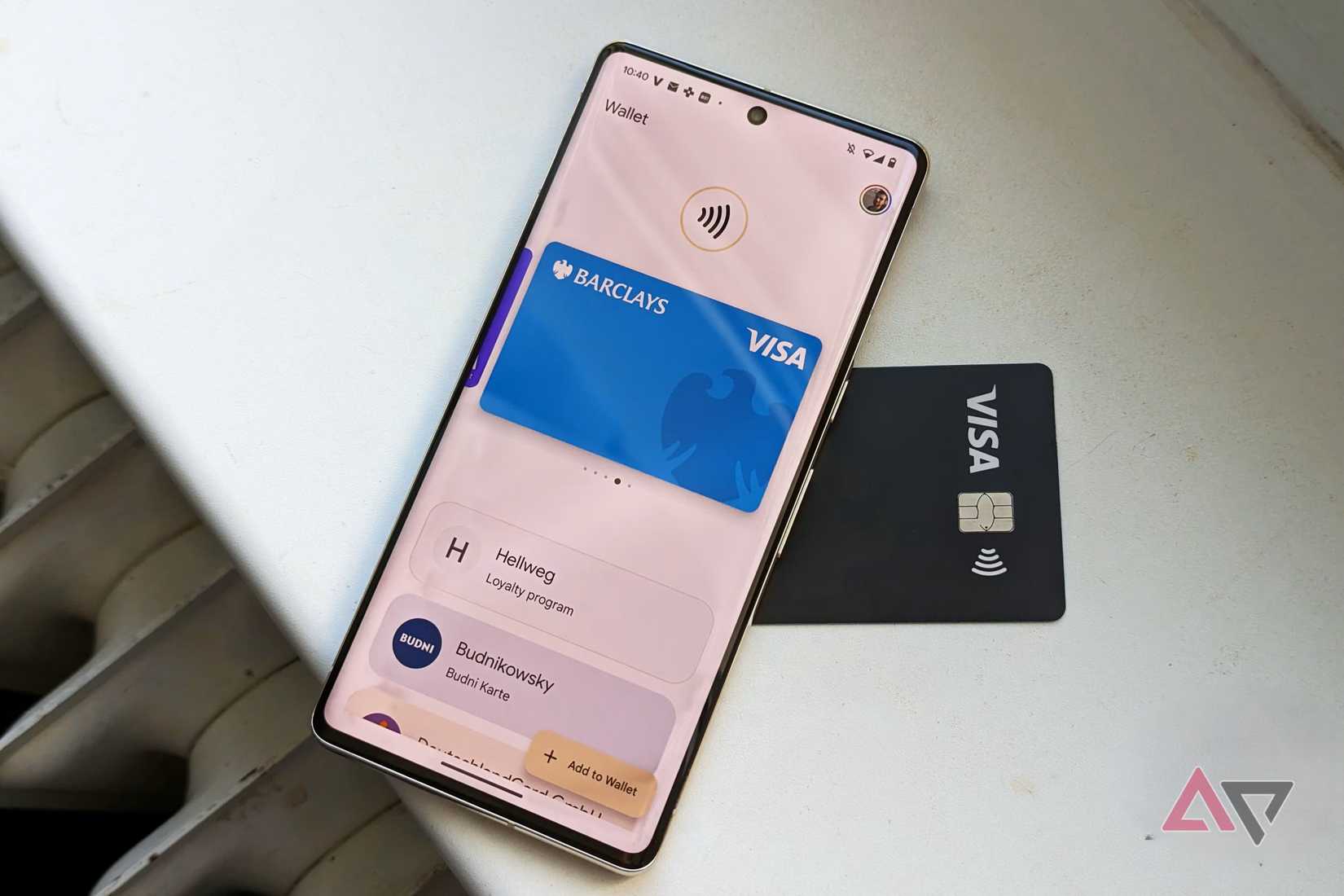 Google Wallet open on a Google Pixel phone resting on top of a black Visa card.