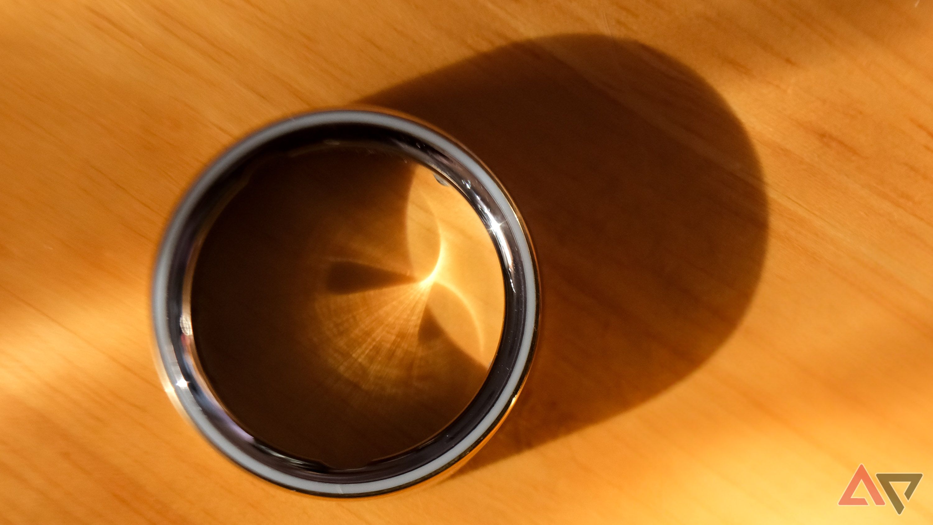 The Oura Ring 4 casting a shadow on a desk.
