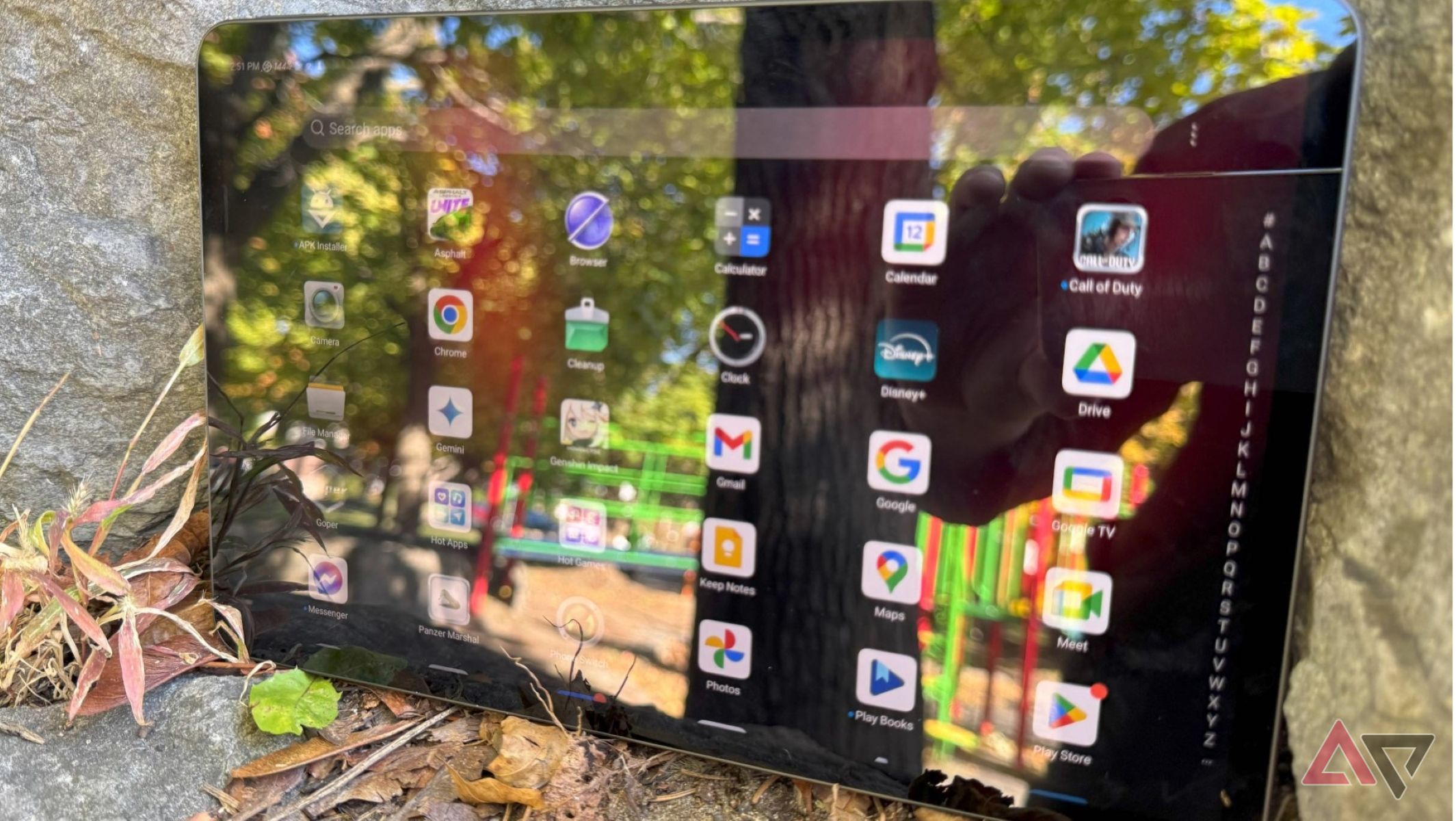 A Redmagic Nova gaming tablet on some rocks with the app drawer open on the screen.