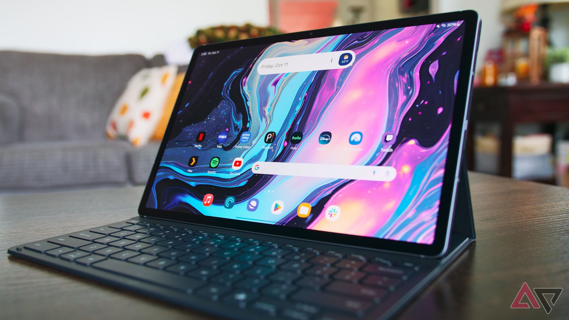 The Galaxy Tab S10+ sitting on a table in its keyboard dock with the display on.