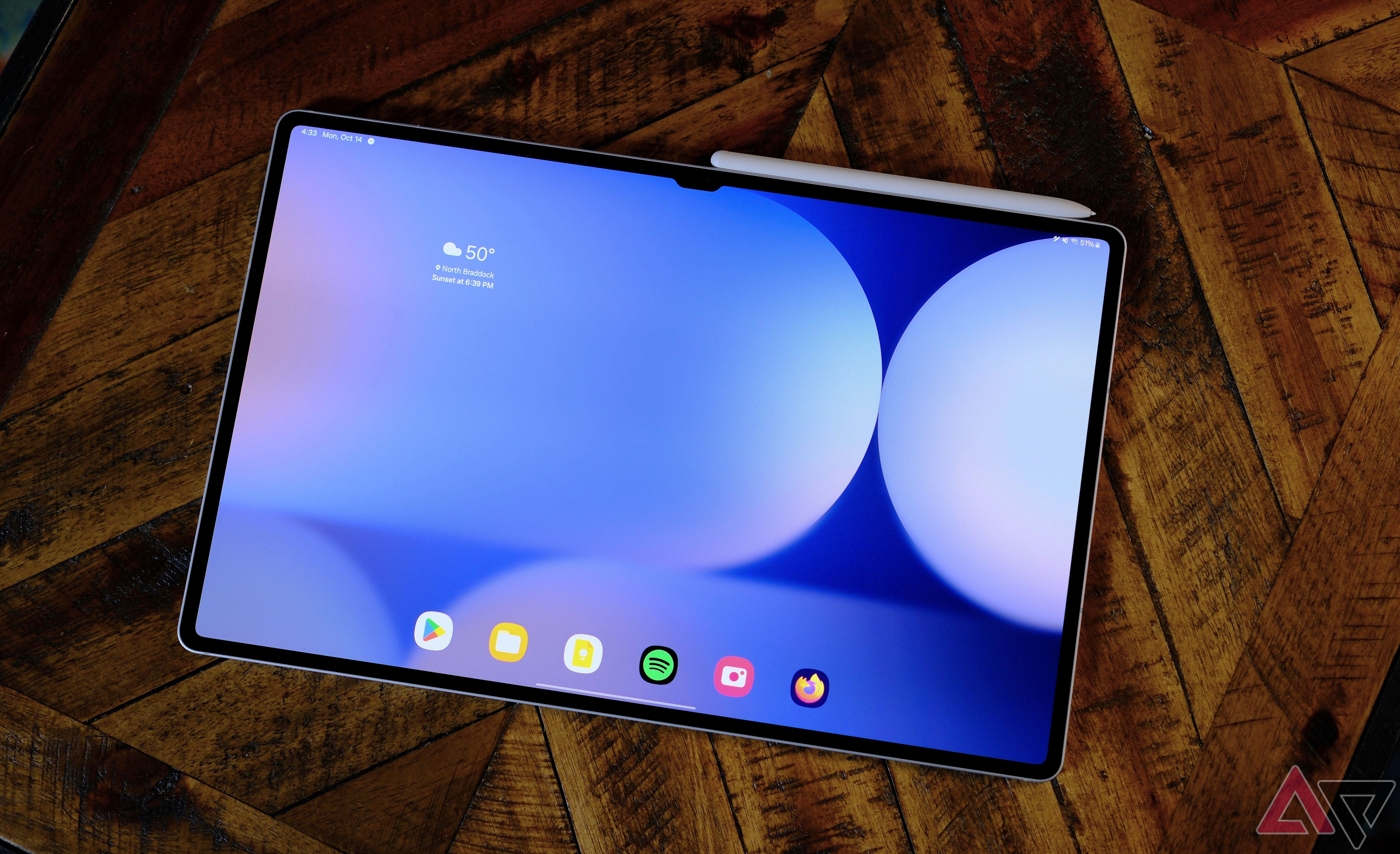 Samsung Galaxy Tab S10 Ultra laying on wood table with screen showing home