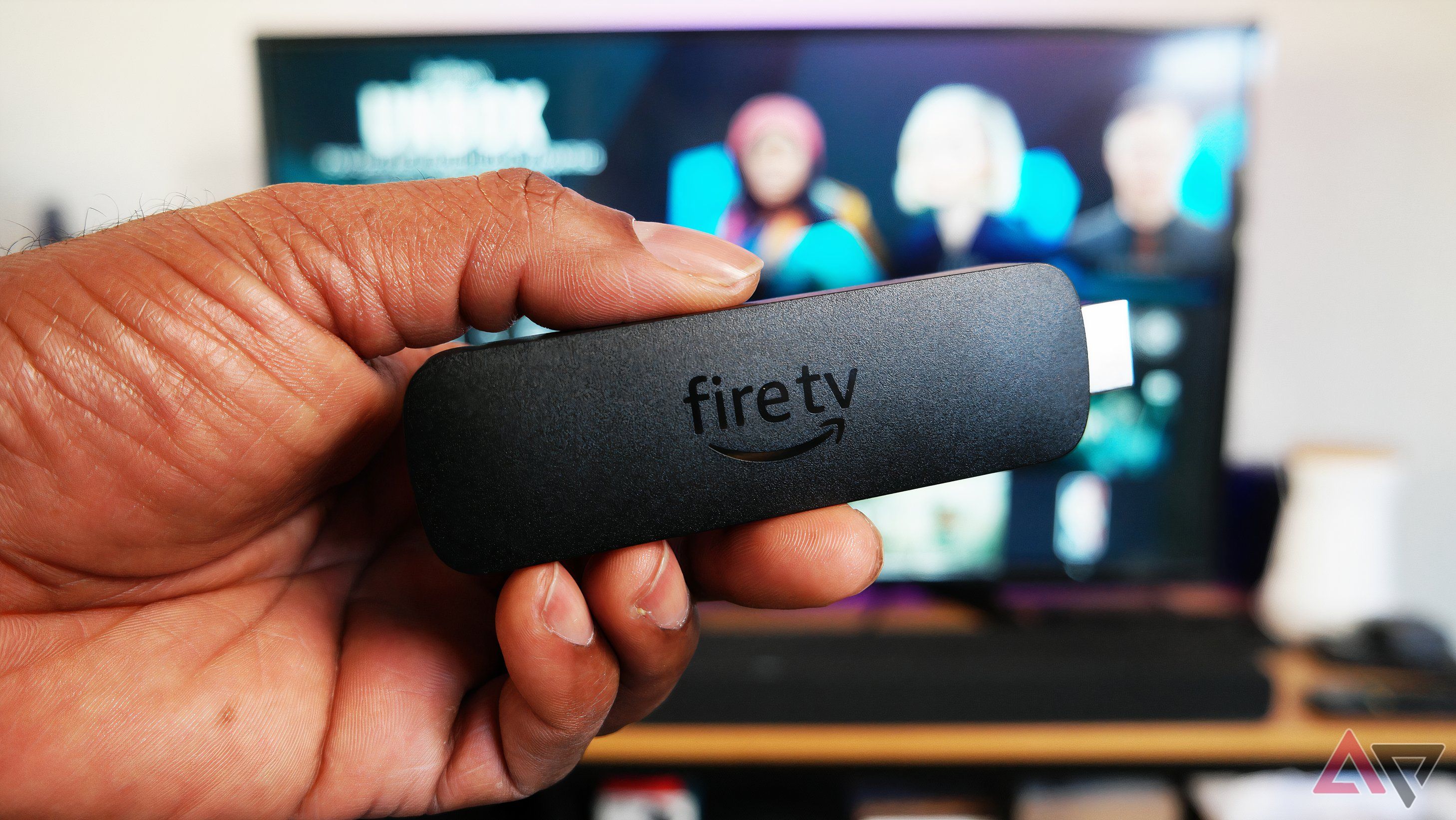 Amazon Fire TV Stick chỉ cơ thể 4K, được hiển thị trước TV chạy lửa hệ điều hành