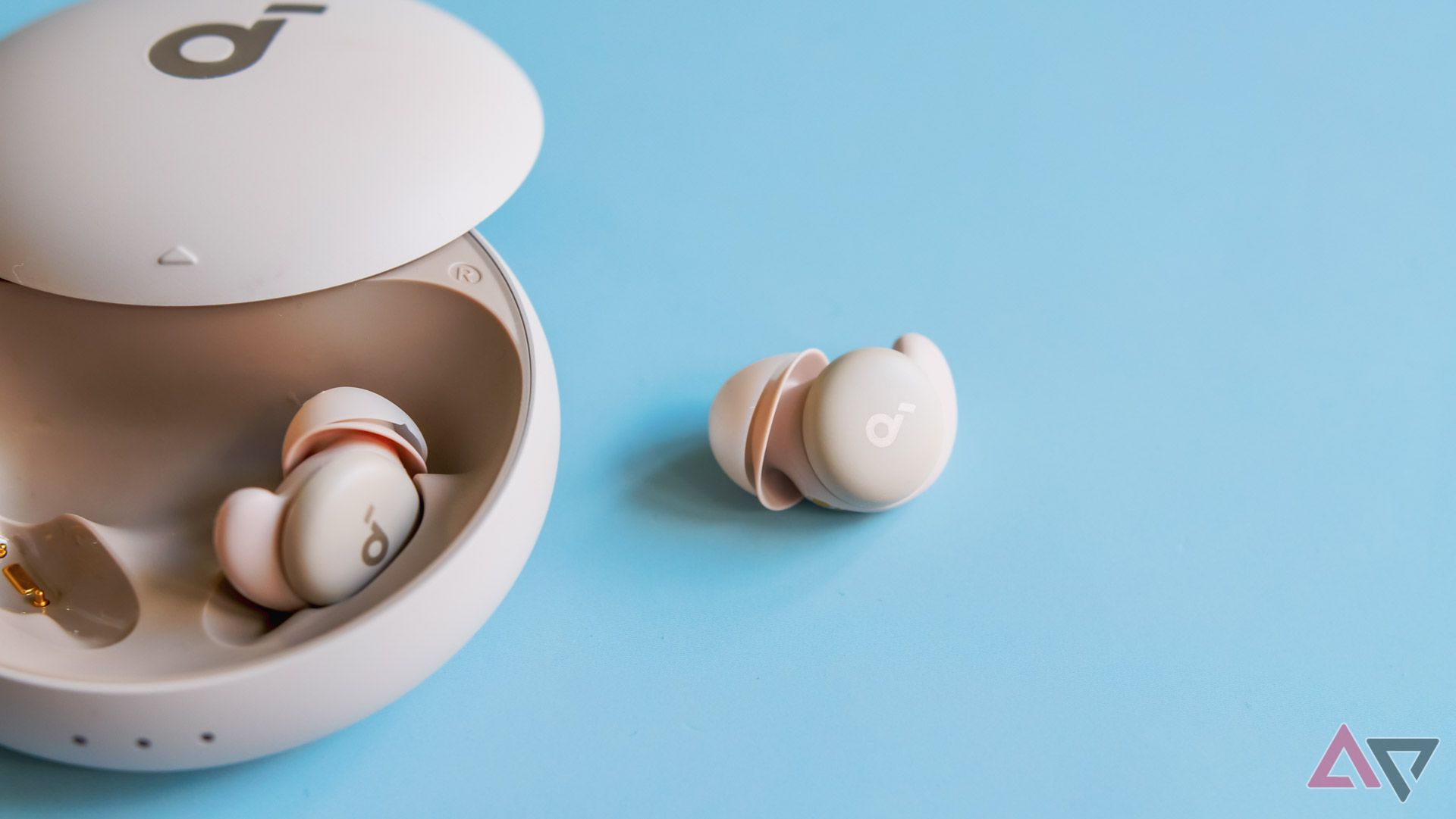 The Anker Soundcore Sleep A20 earbuds with one earbud outside of the case.