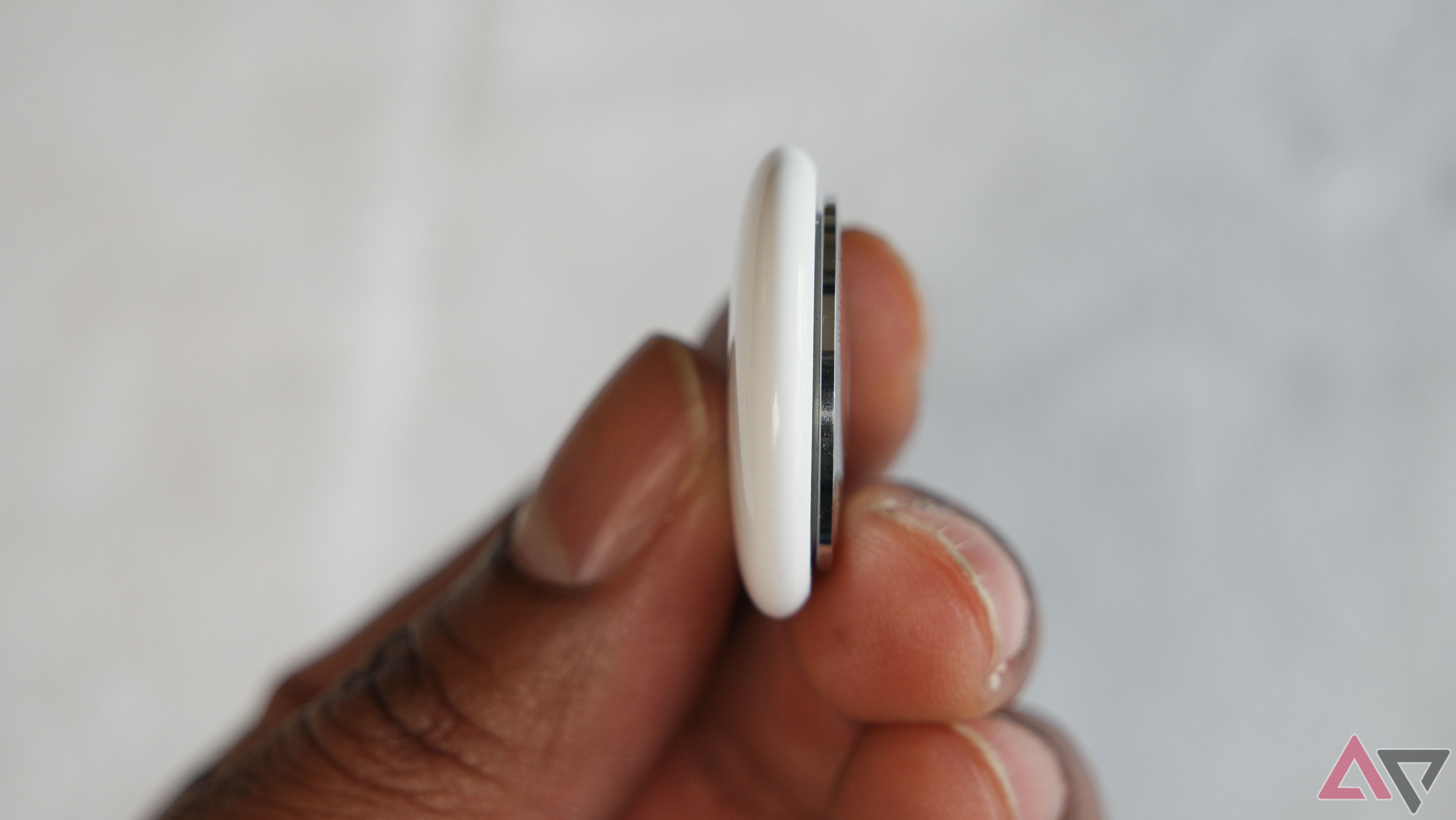 apple airtag thickness side view in hand