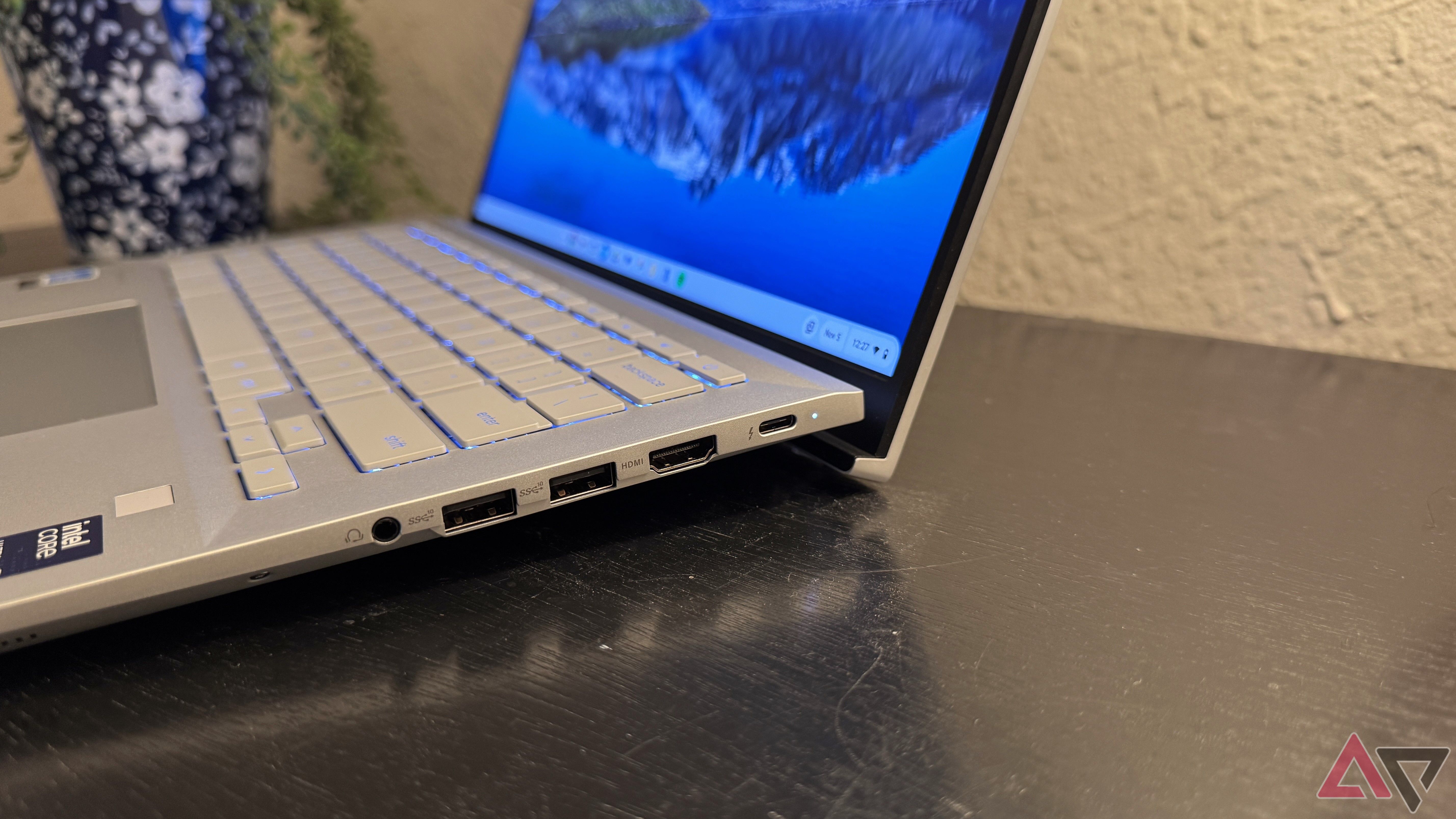 Asus Chromebook Plus CX54 showing the hinge on a black surface with a white background.