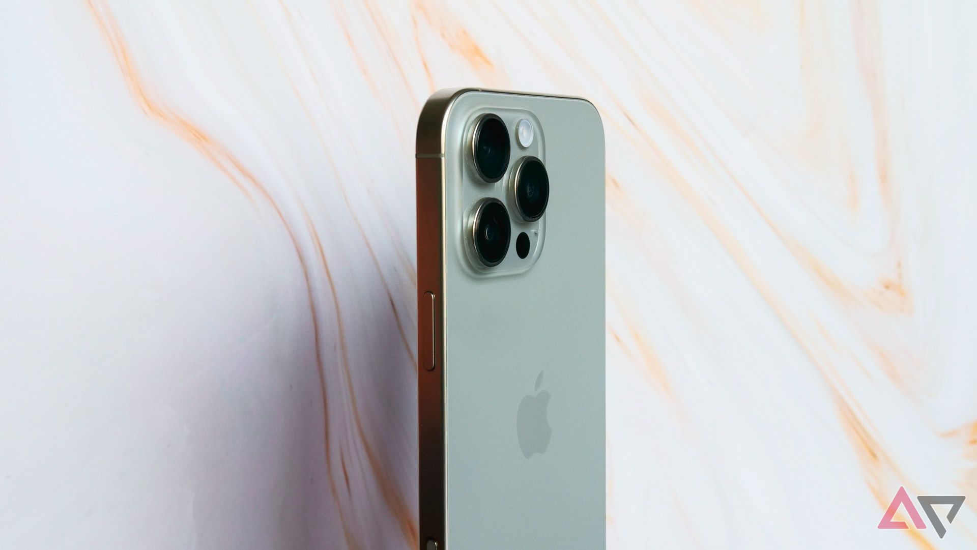 The iPhone 16 Pro Max standing against a cream backdrop.