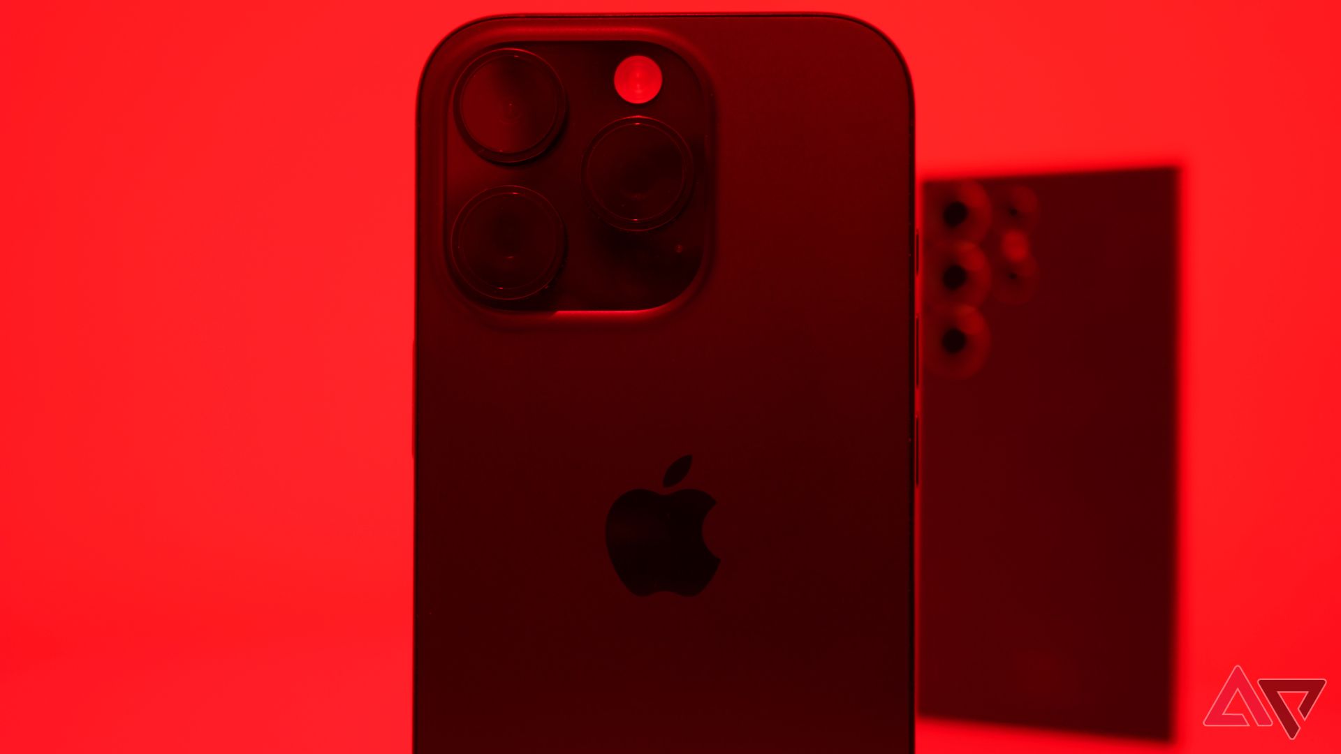 An iPhone 16 Pro and S24 Ultra bathed in red light