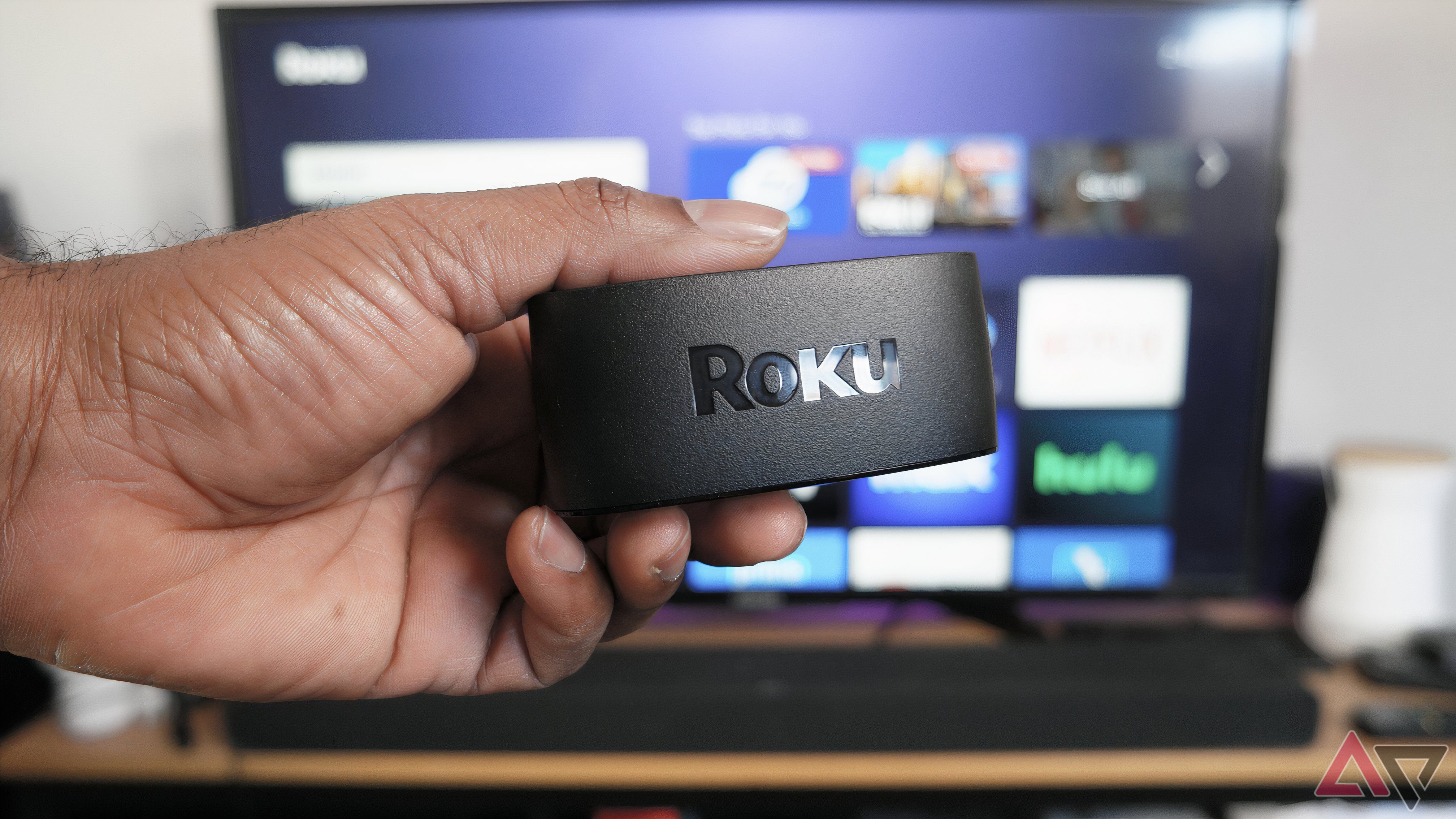 The Roku Express 4K+ dongle in front of a TV