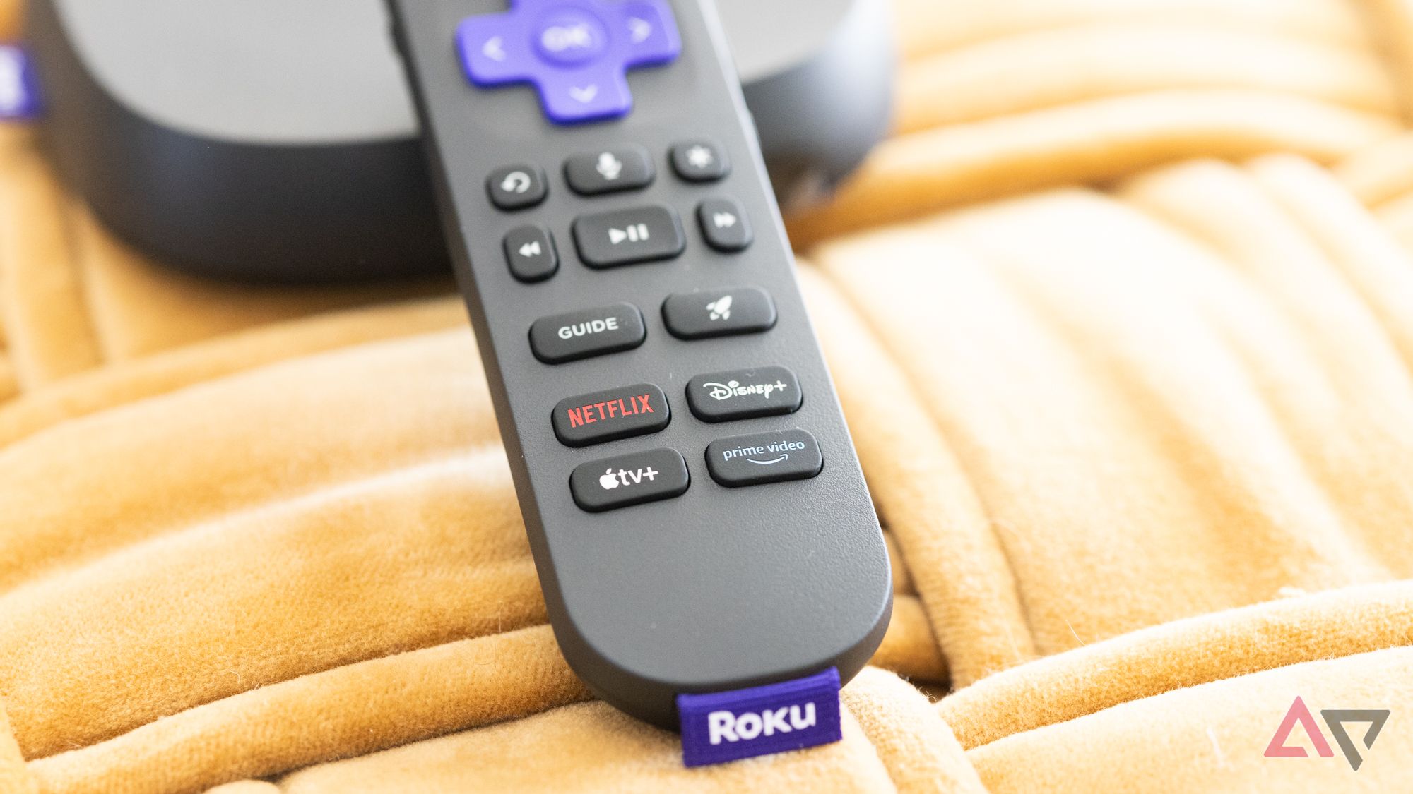 The Roku Ultra Voice Remote Pro showing the dedicated buttons on a yellow background