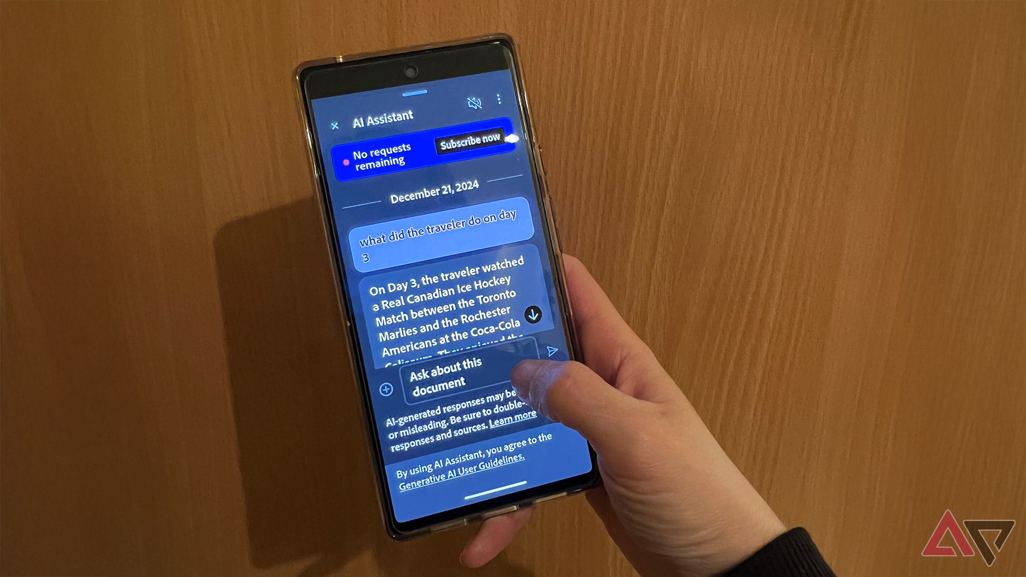 Hand holding a phone showing Adobe Acrobat's AI Assistant Voice Command