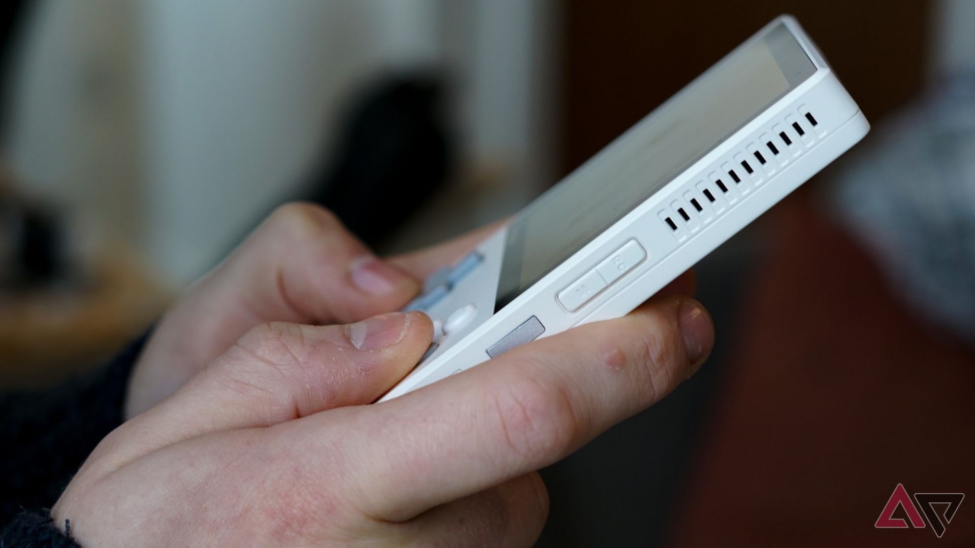 person holding white ayaneo pocket dmg console with both hands