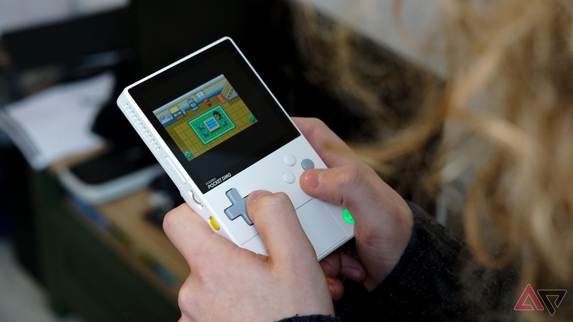 person playing game on white ayaneo pocket dmg console