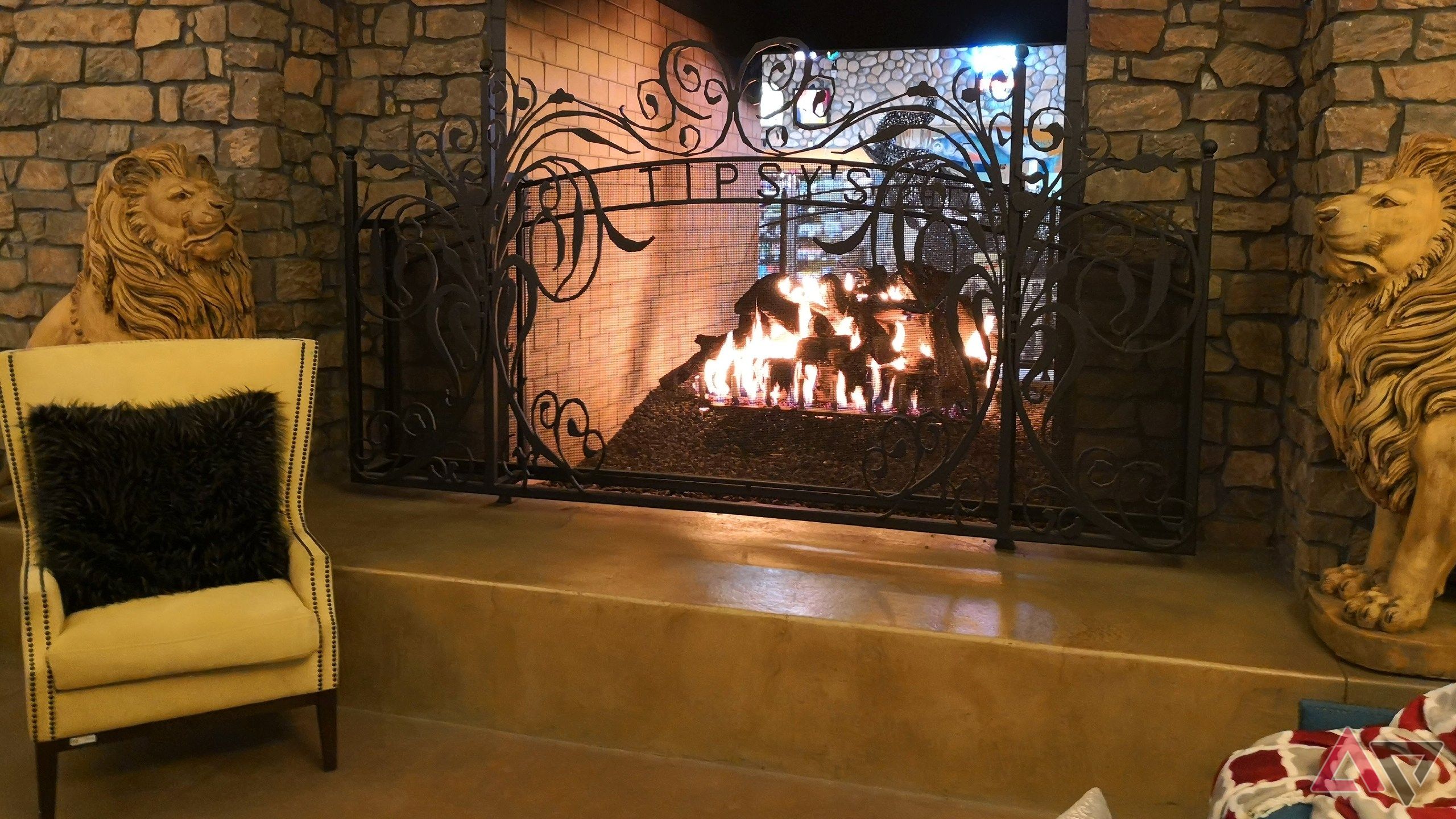 A lit fireplace and yellow chair