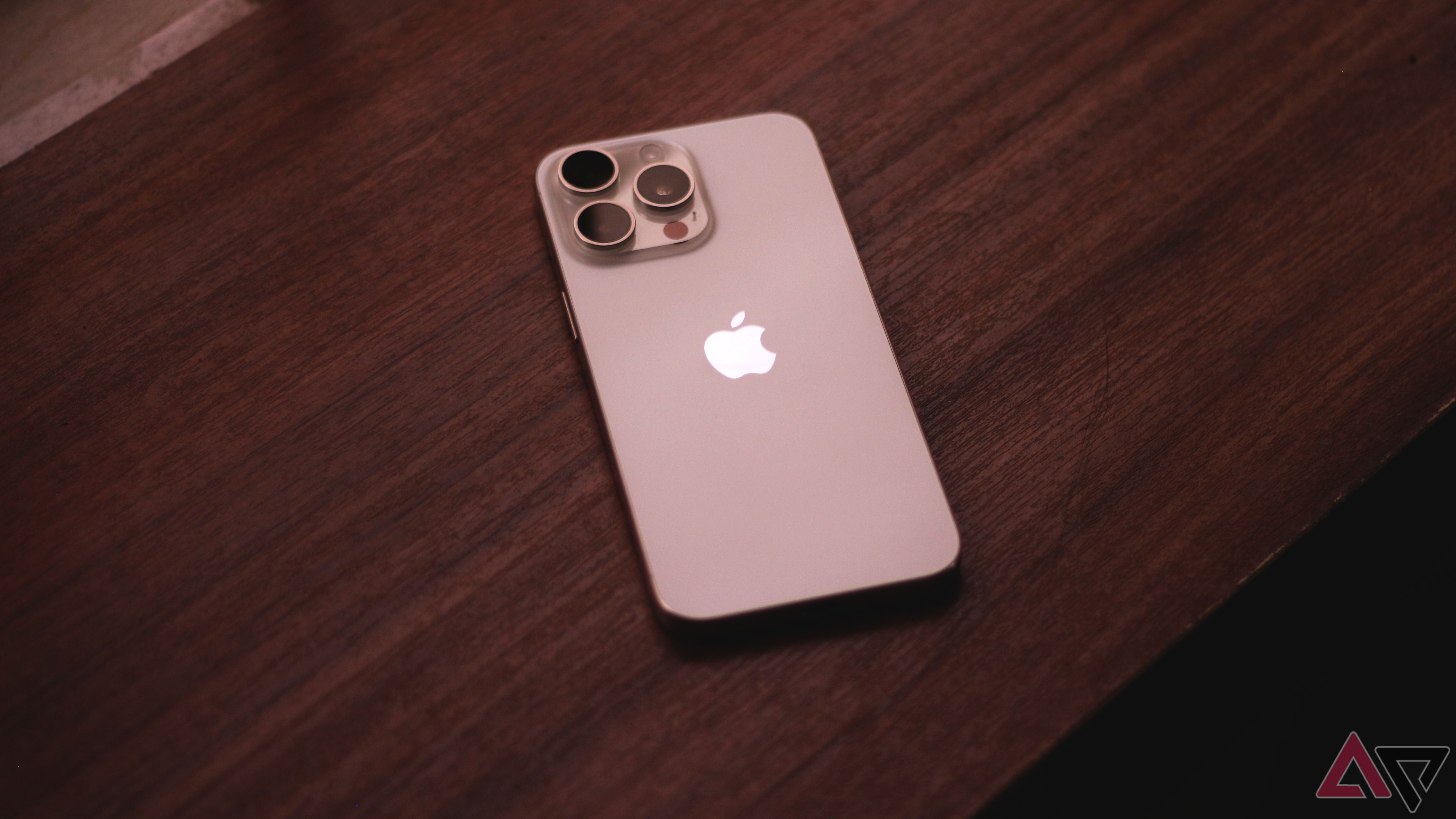 A white iPhone 15 Pro Max laying flat on a wooden surface