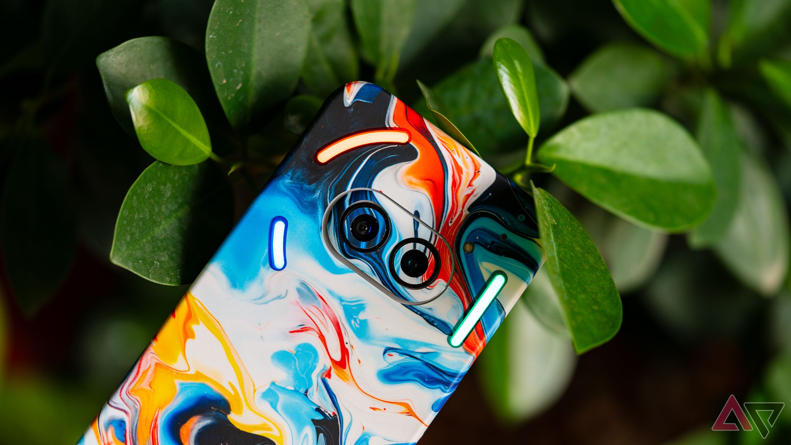Nothing Phone 2a with a colorful marbly skin clicked with a plant