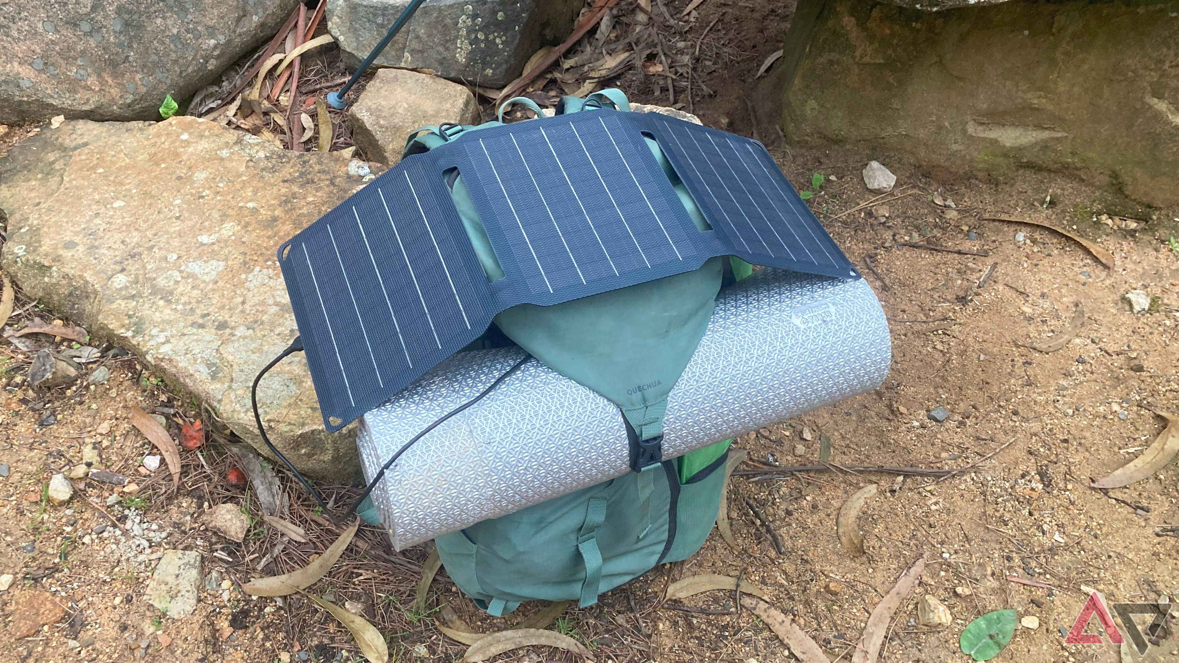 The FlexSolar E15 solar panel mounted on top of a hiking backpack in nature